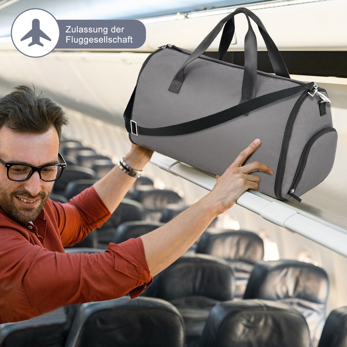 Un hombre con gafas coloca una bolsa gris en el compartimento superior de un avión. Asientos visibles al fondo.