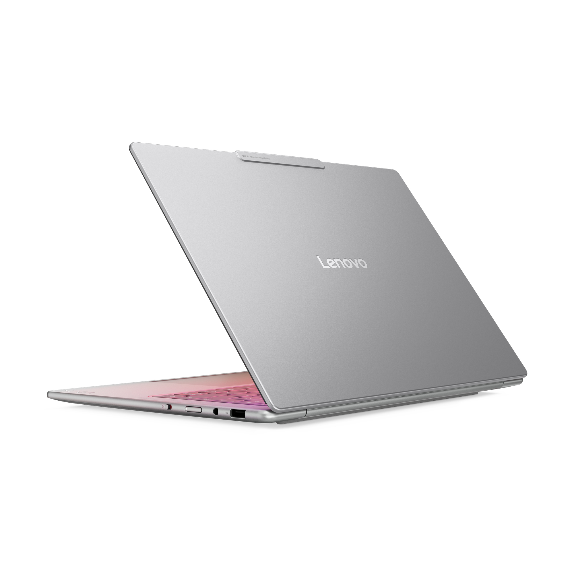 Un laptop Lenovo argentato è leggermente aperto su sfondo bianco. La tastiera ha un'illuminazione rosa.