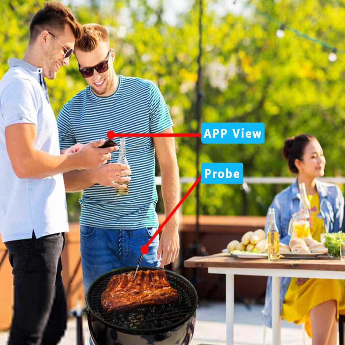 Zwei Männer schauen auf einem Telefon in der Nähe eines Grills mit Rippchen nach. Eine Sonde befindet sich in den Rippen. Eine Frau sitzt im Hintergrund an einem Tisch.