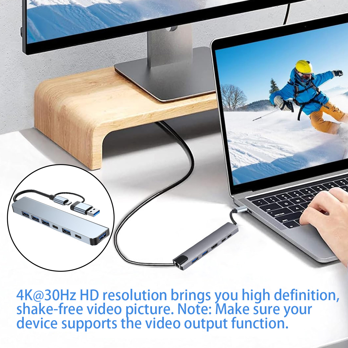 Laptop, verbunden mit einem Hub, zeigt einen Skifahrer. Hub und Monitor stehen auf einem Holzständer.
