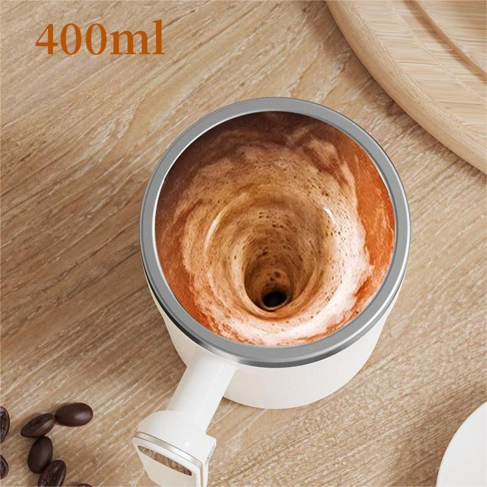 Eine weiße Tasse mit einem wirbelnden Kaffeegetränk. Holzuntergrund mit Kaffeebohnen.