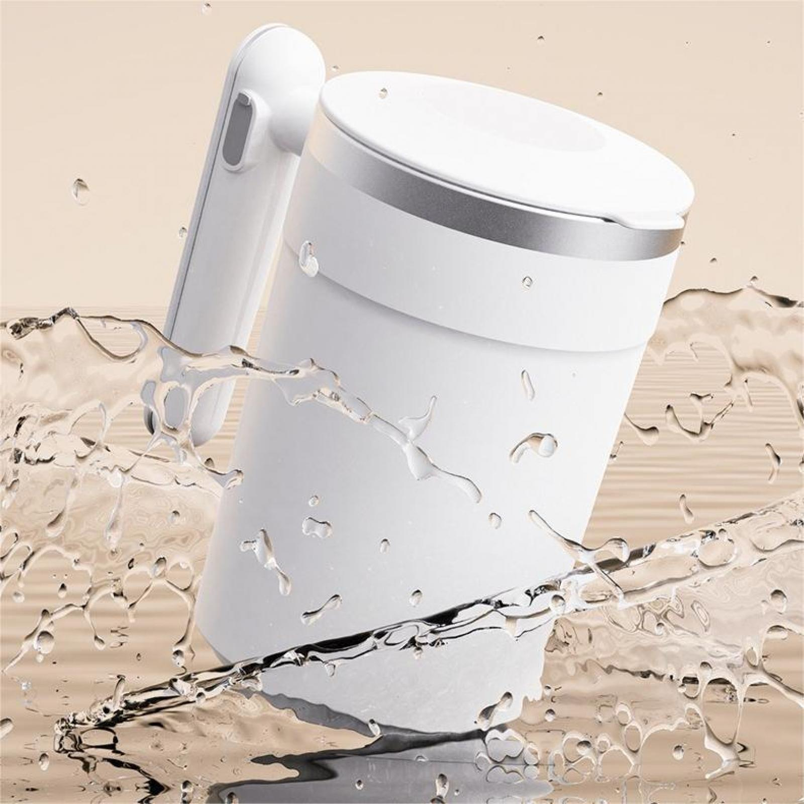 Weißer Reisekessel mit Griff, silberner Zierleiste, Wasserspritzern. Neutraler Hintergrund.