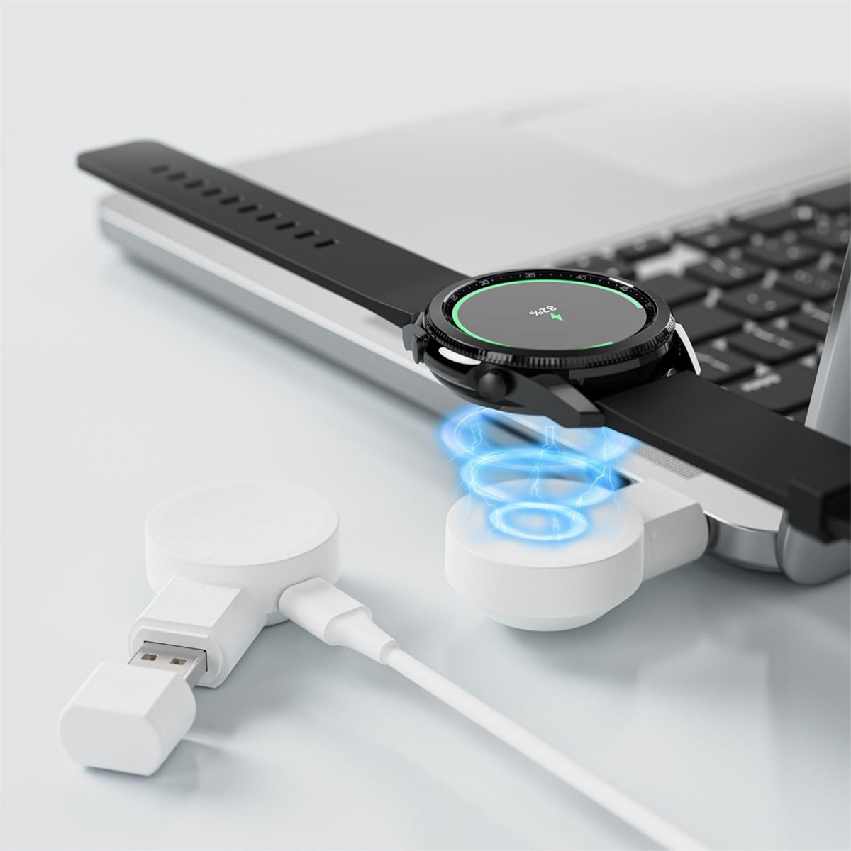 Eine schwarze Smartwatch, die auf einem weißen kabellosen Ladegerät aufgeladen wird. Ein Laptop ist im Hintergrund.