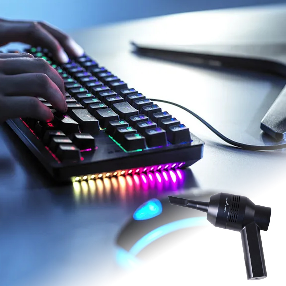 Hände tippen auf einer hintergrundbeleuchteten Tastatur. Ein schwarzer Luftstaubsauger befindet sich neben einer leuchtenden Maus.