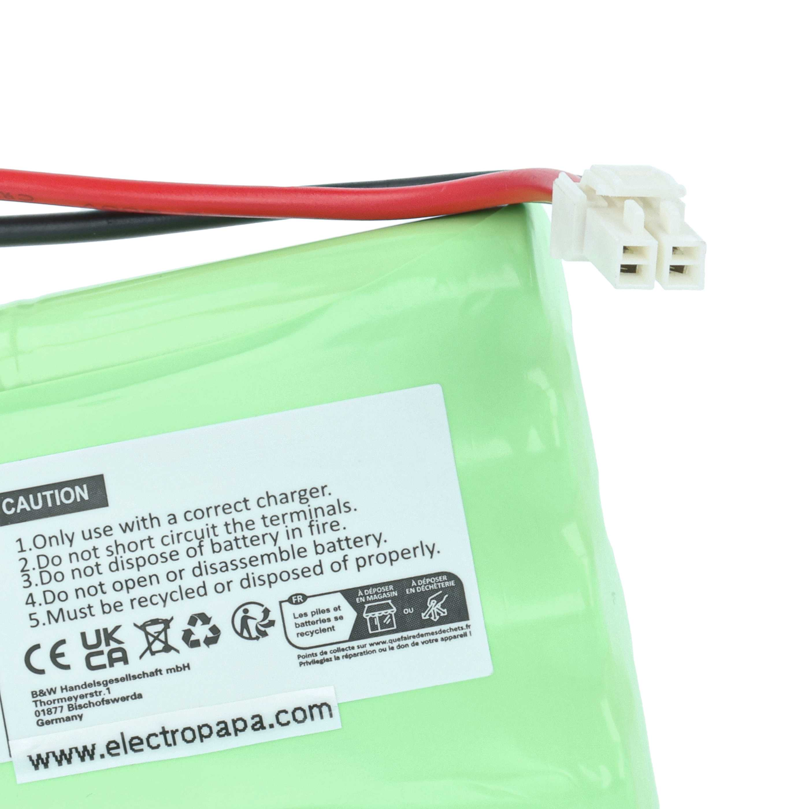 Eine grüne Batterie mit weißem Stecker und rot/schwarzen Drähten. Text über Recycling und Sicherheit ist sichtbar.