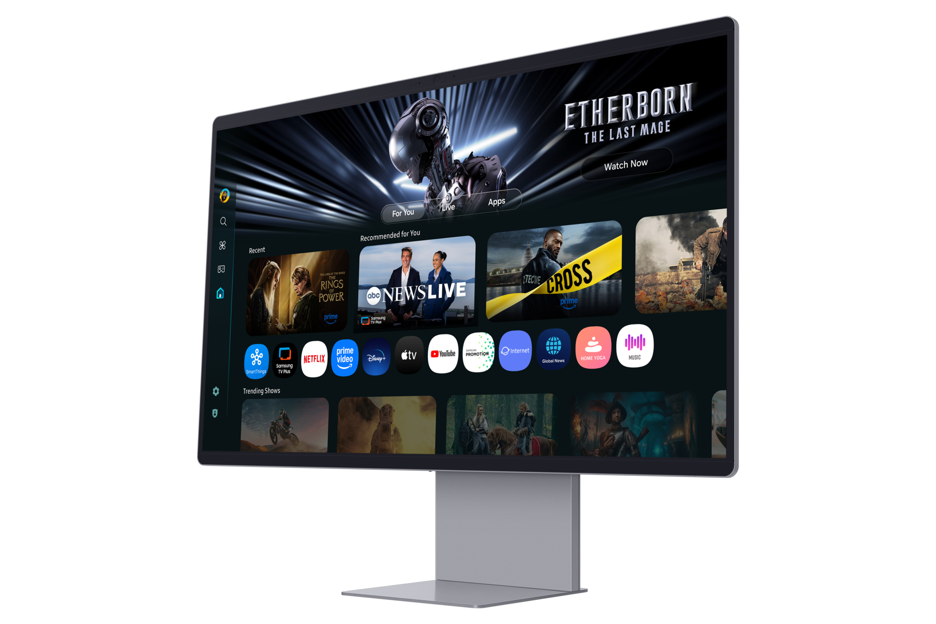 Un grande televisore mostra app di streaming. I contenuti in primo piano includono 'The Rings of Power' e 'Cross'. Lo schermo è su un supporto argentato.