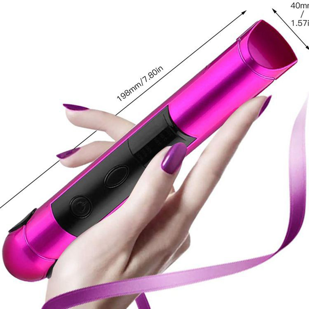 Ein rosa-schwarzes Glätteisen wird in einer Hand mit lila Nagellack gehalten. Ein lila Band ist sichtbar. Maße werden angezeigt.