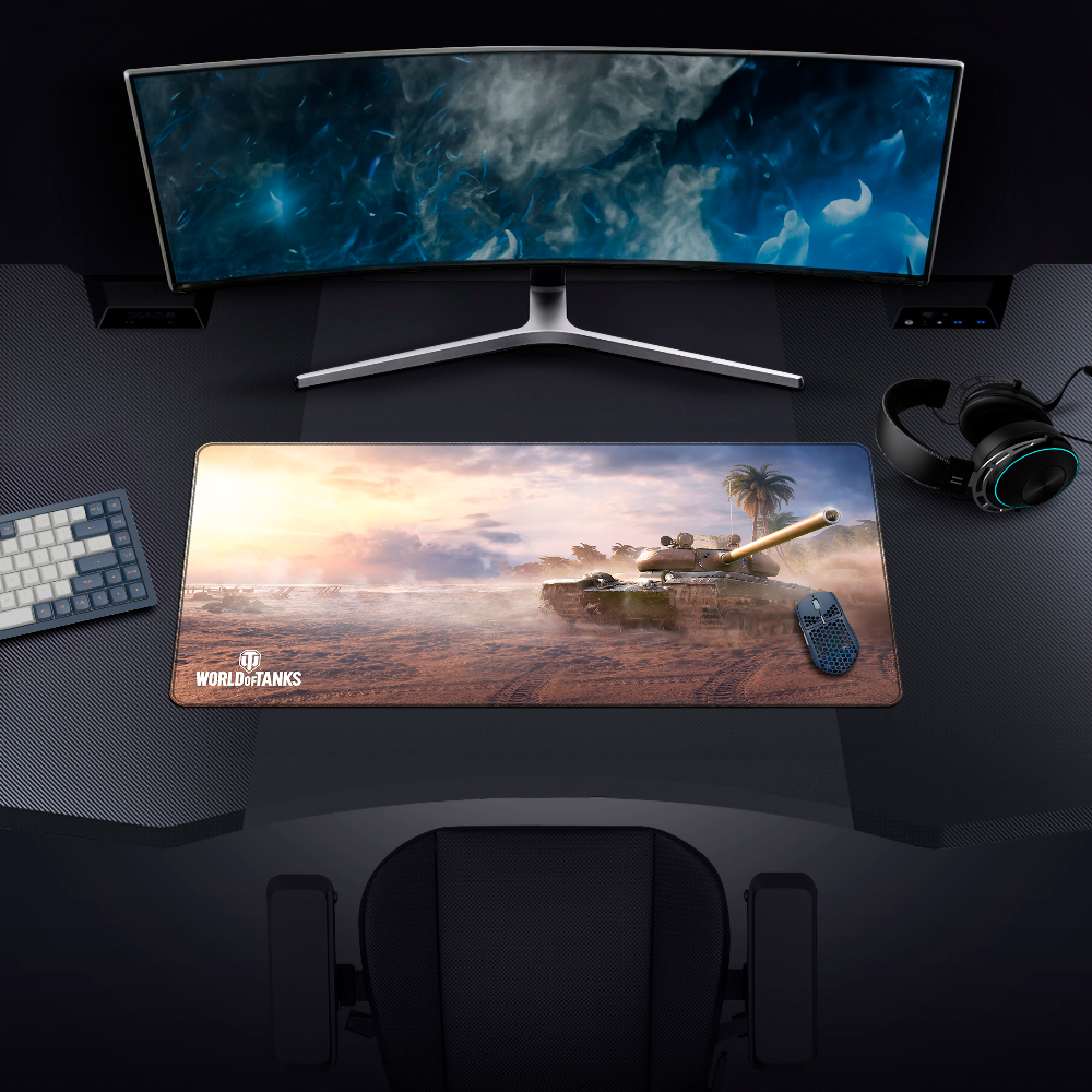 Configurazione di gioco con monitor, tastiera, mouse e cuffie. Mousepad con immagine di un carro armato di World of Tanks.