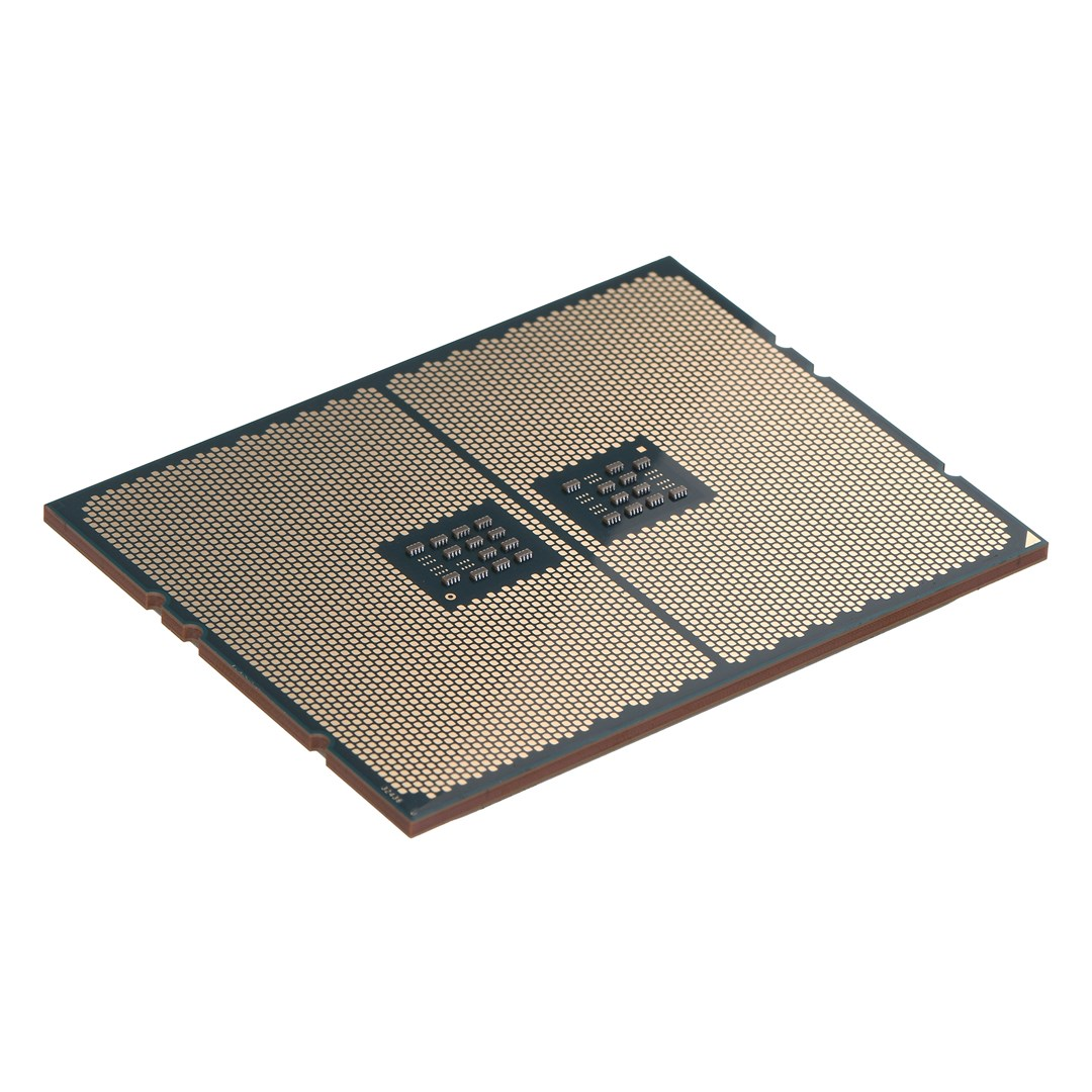 Komponent procesora z złotą powierzchnią i małymi czarnymi kwadratami. Widoczne brązowe krawędzie. Tło jest białe.