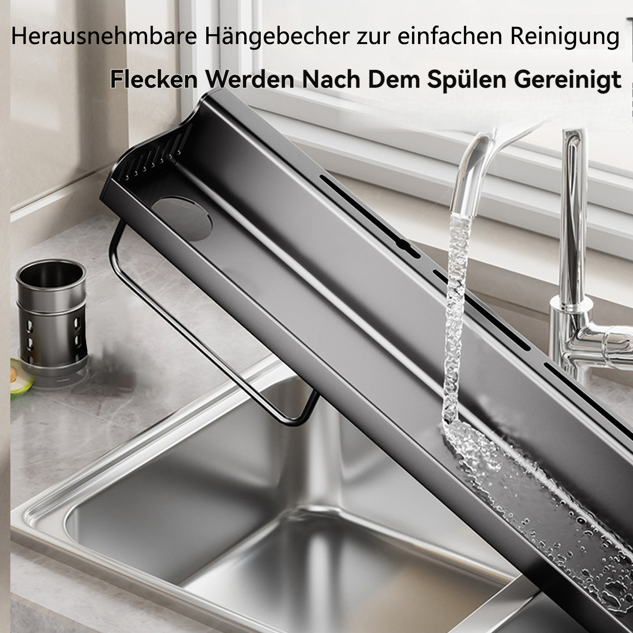 Ein schwarzes Abtropfgestell über einem Edelstahlbecken. Wasser fließt aus einem Wasserhahn. Links ein Metallbehälter.