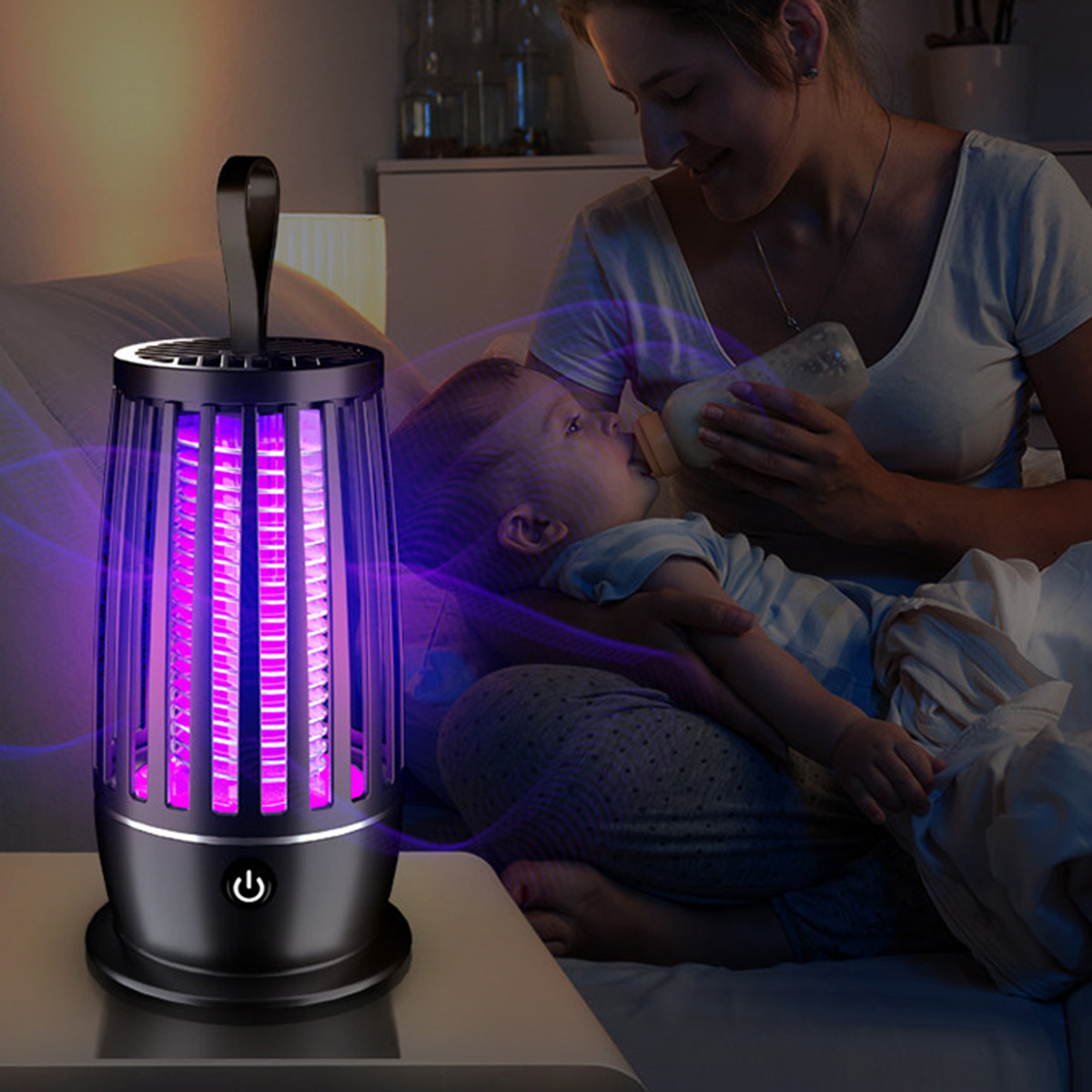 Eine Mutter füttert ein Baby mit einer Flasche. Auf dem Tisch steht ein Insektenvernichter mit violettem Licht. Der Raum ist schwach beleuchtet.