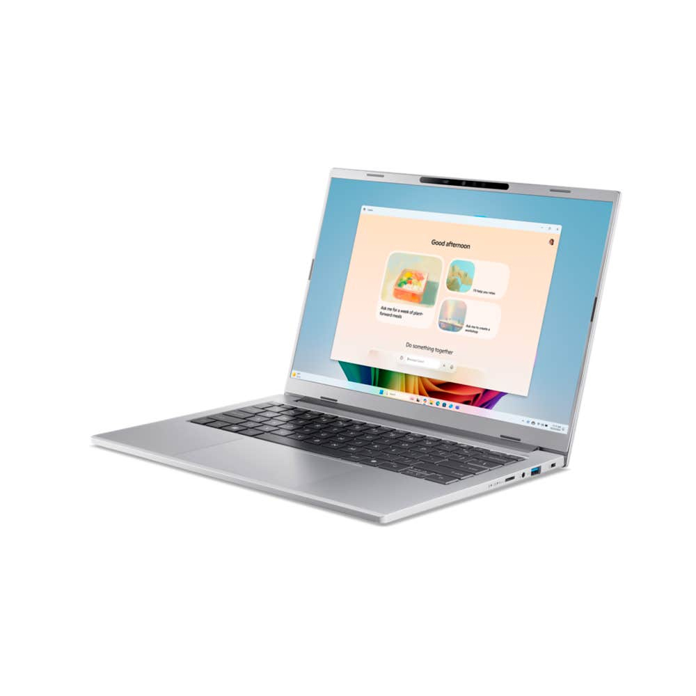 Srebrny laptop, otwarty, wyświetla ekran z interfejsem 'Dobrego popołudnia', czarną klawiaturą i białym tłem.