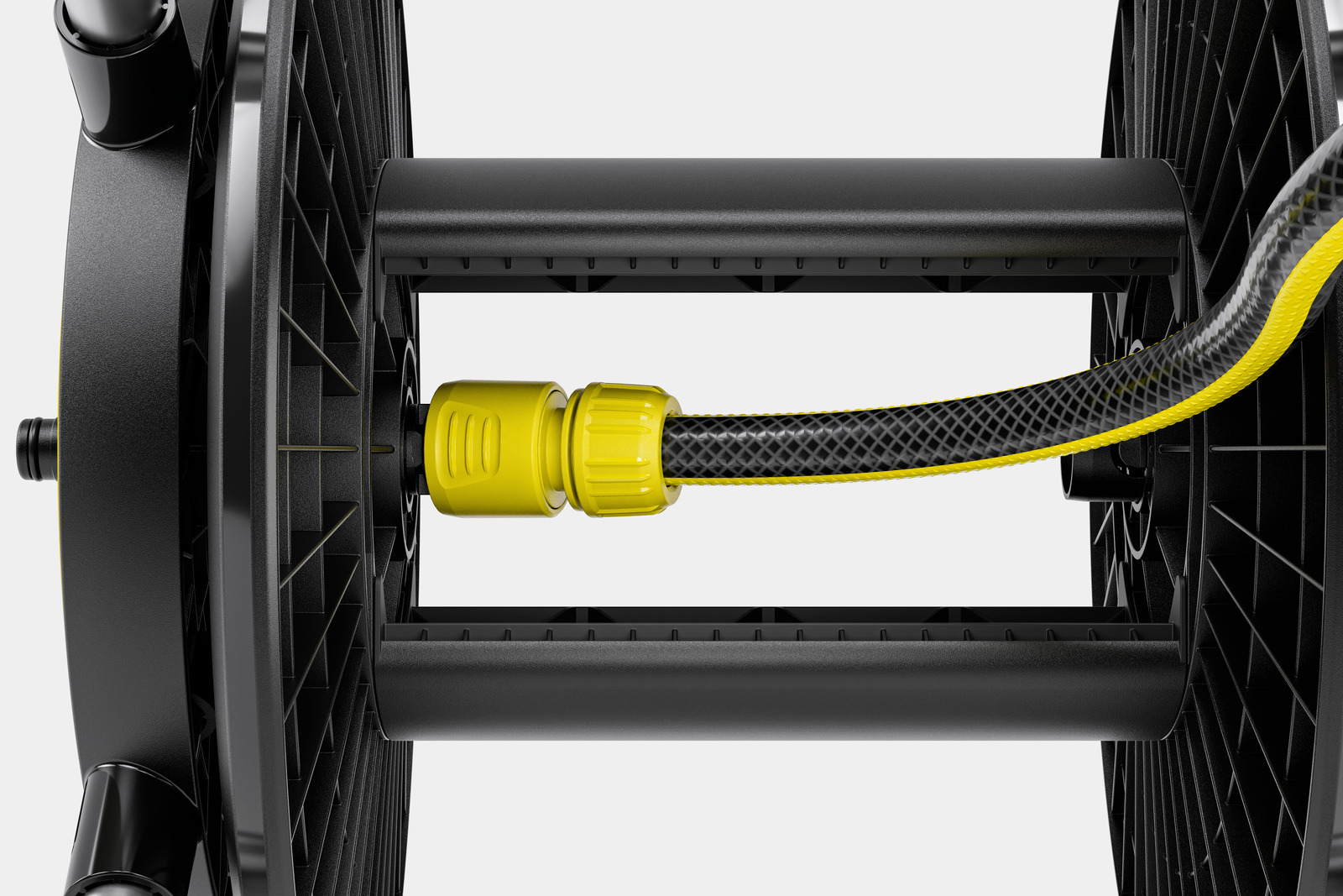 Czarny bęben na wąż z podłączonym wężem. Wąż jest czarny z żółtymi krawędziami, przymocowany do żółtego łącznika.