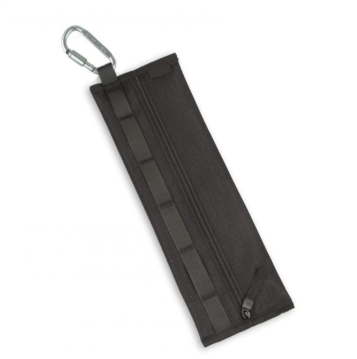 Eine schwarze Tasche mit einem silbernen Karabiner. Sie hat einen Reißverschluss und mehrere Riemen auf der Vorderseite. Der Hintergrund ist weiß.
