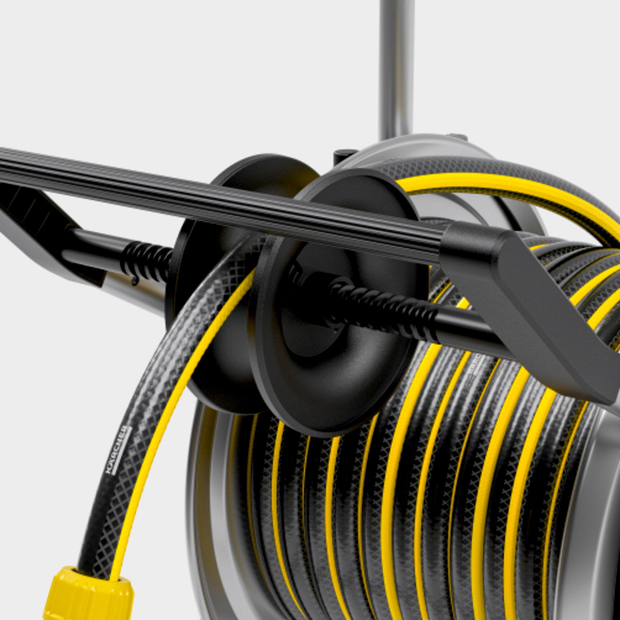 Czarny i żółty bęben na wąż. Wąż jest czarny z żółtymi paskami. Bęben jest czarny i srebrny.