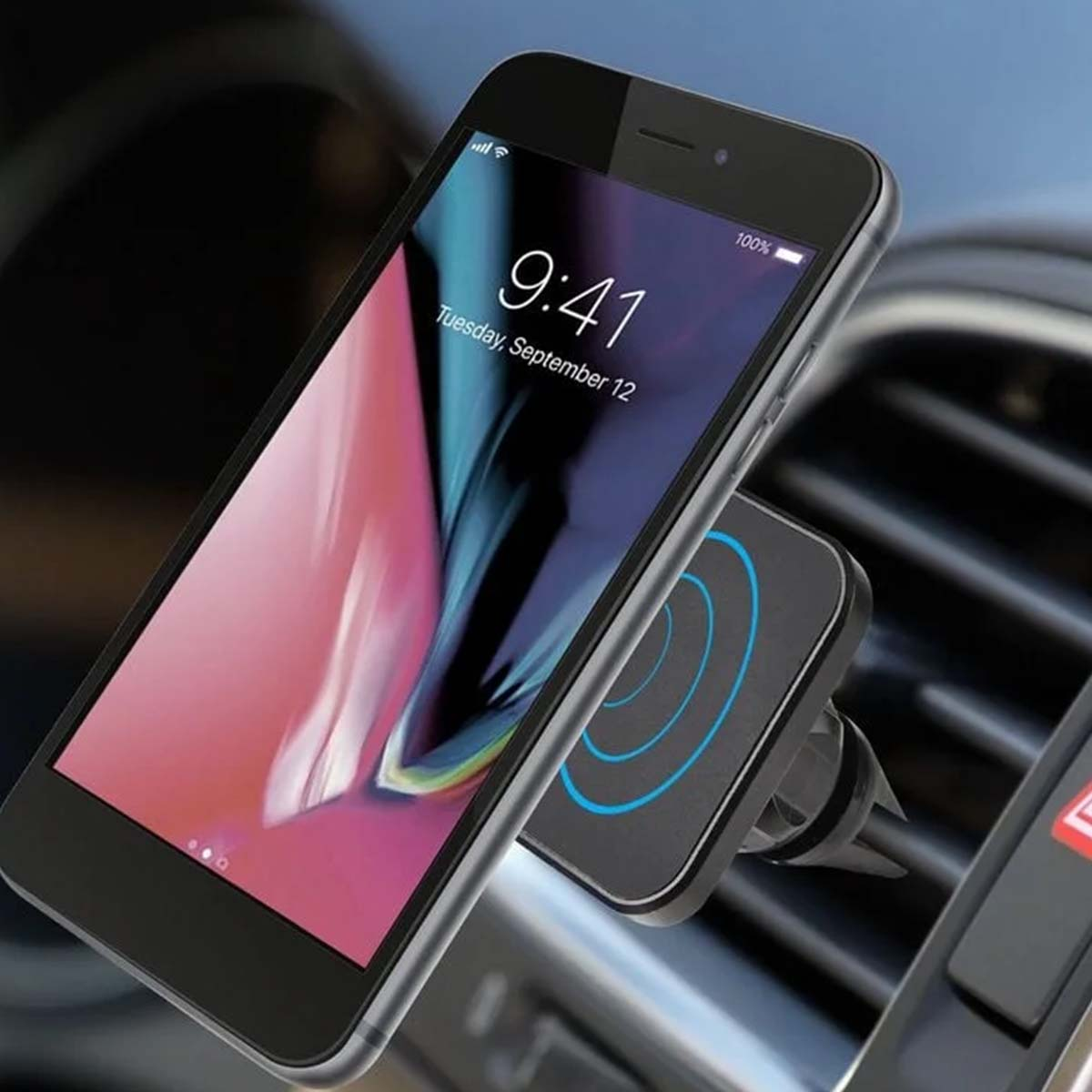 Un teléfono inteligente que muestra las 9:41 está montado en un soporte de ventilación del coche. La pantalla muestra un fondo rosa y azul.