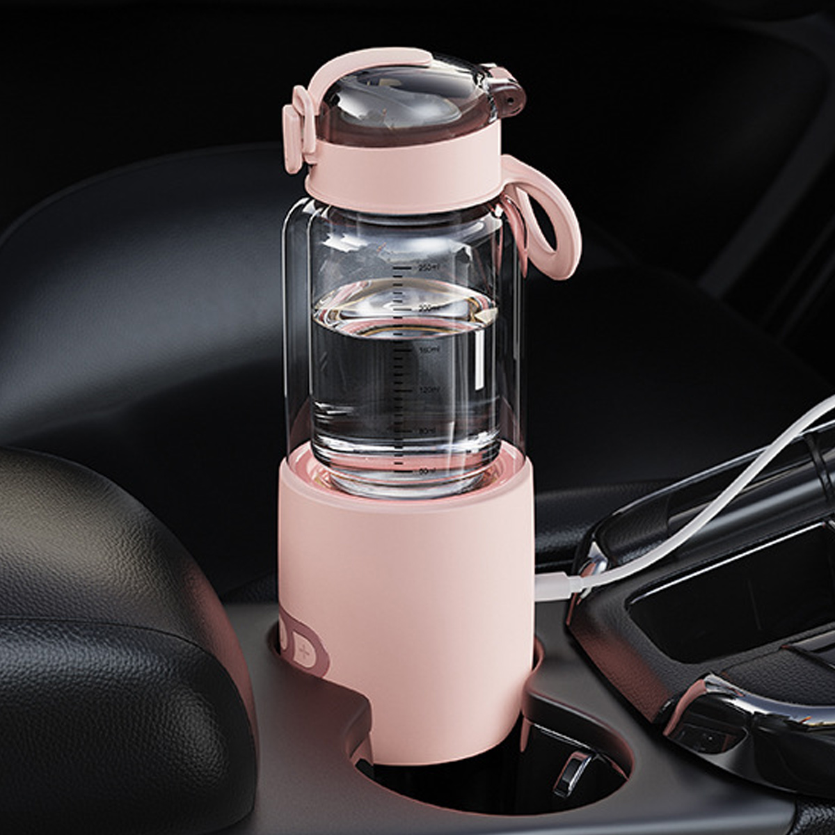 Eine rosa Wasserflasche in einem Getränkehalter im Auto. Die Flasche ist mit Wasser gefüllt. Der Innenraum des Autos ist schwarz.