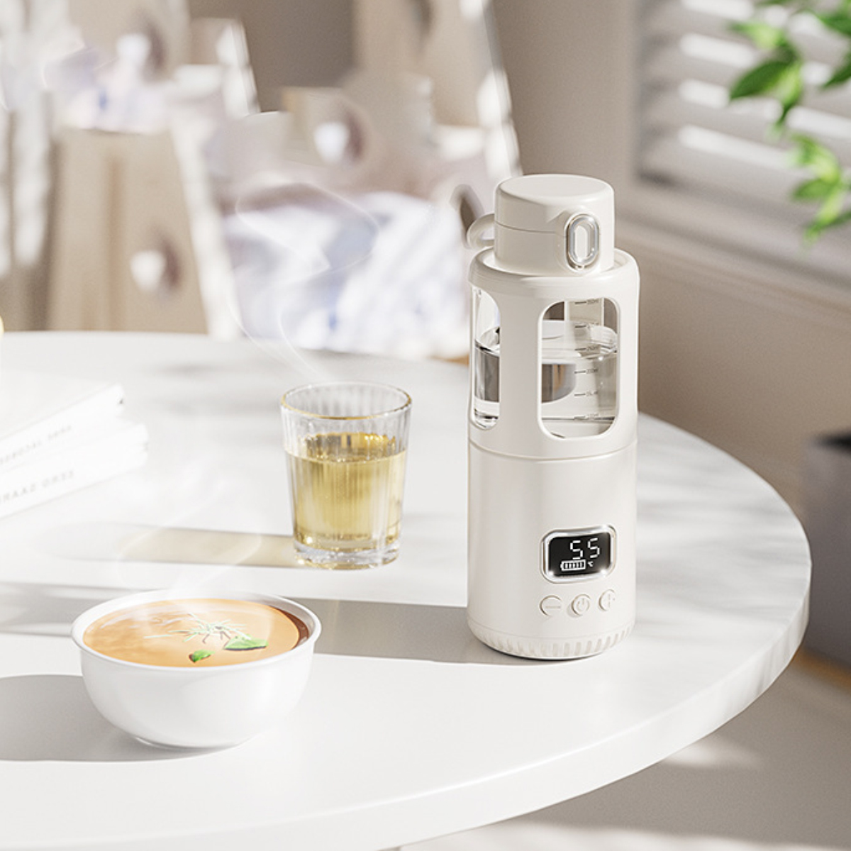 Weiße Wasserflasche, Glas Tee, Schüssel mit Suppe auf weißem Tisch. Verschwommener Hintergrund mit Stühlen und Fenster.