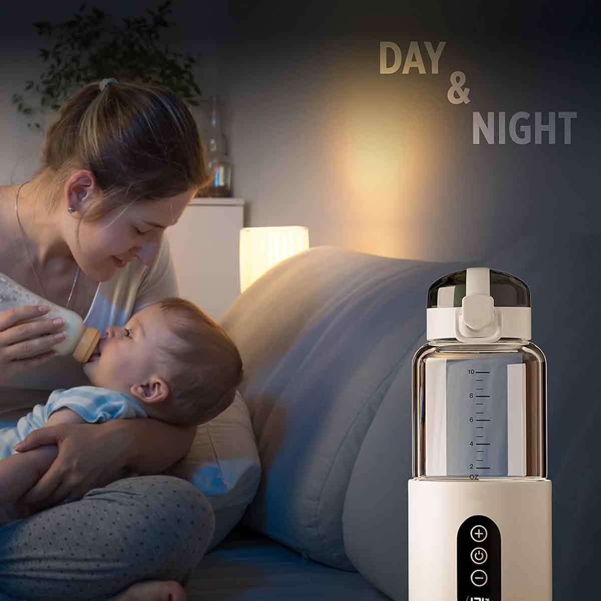 Eine Mutter füttert ein Baby mit einer Flasche. Ein Flaschenwärmer befindet sich im Vordergrund. Die Worte 'TAG & NACHT' stehen an der Wand.