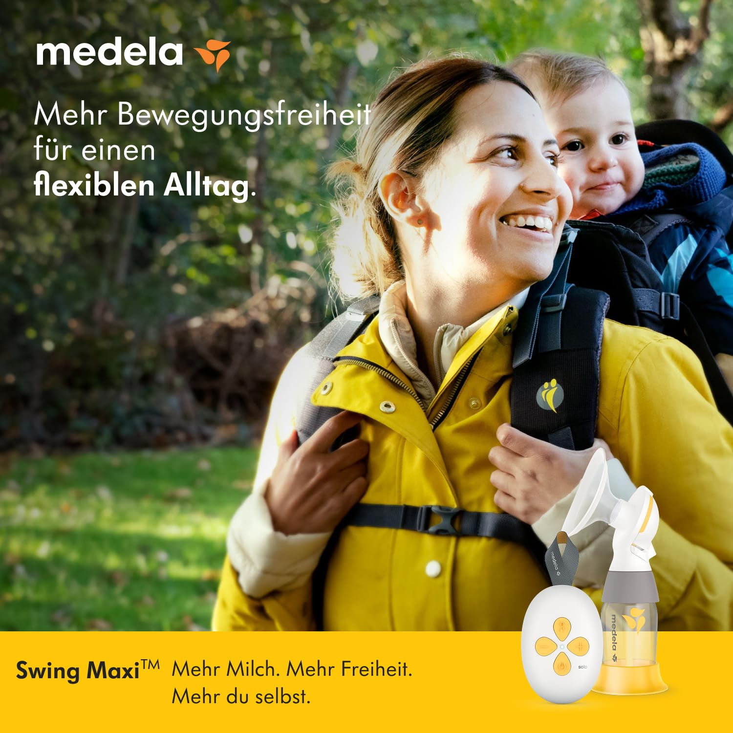Eine Frau lächelt, während sie ein Baby in einer Trage trägt. Sie trägt eine gelbe Jacke. Vor ihr befindet sich eine Brustpumpe.