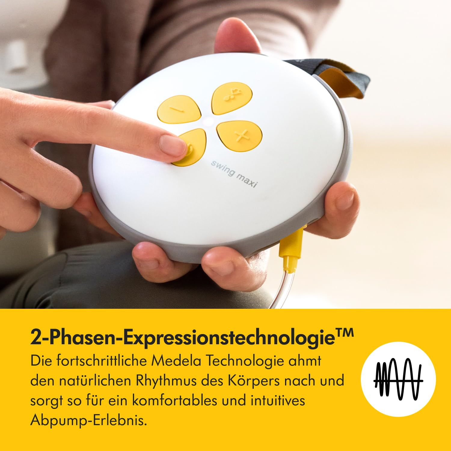 Eine Hand drückt auf eine Taste einer weißen und grauen Milchpumpe. Gelbe Knöpfe sind sichtbar. Die Pumpe hat ein gelbes Kabel.