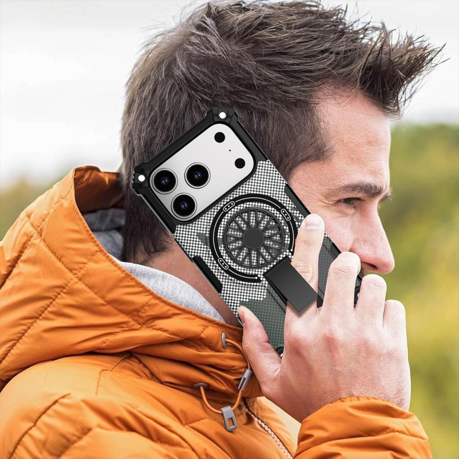 Ein Mann in einer orangefarbenen Jacke hält ein Telefon mit schwarzer Hülle an sein Ohr. Die Handyhülle hat ein schwarz-weißes Design.