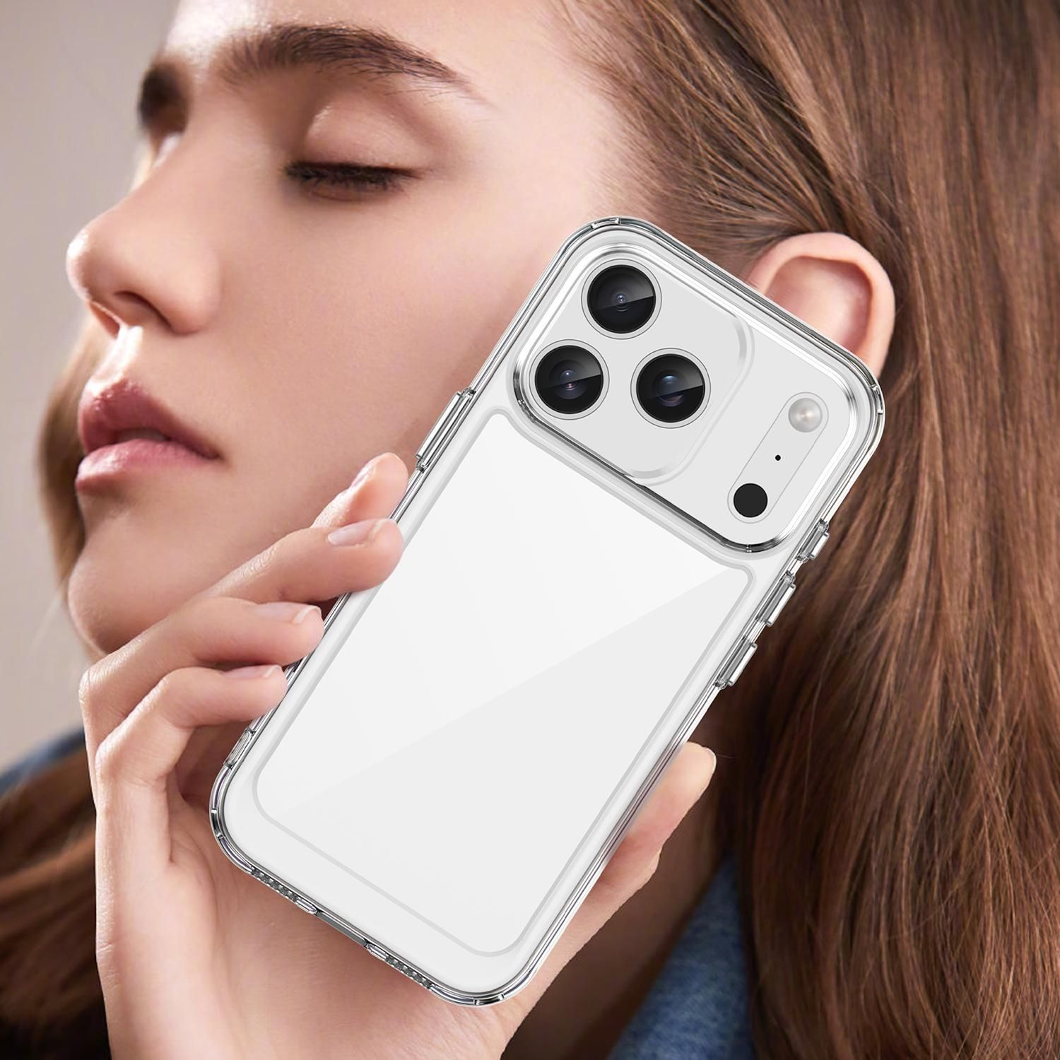 Eine Frau hält eine transparente Handyhülle mit weißer Rückseite. Das Telefon hat drei Kameras. Frau hat braune Haare.