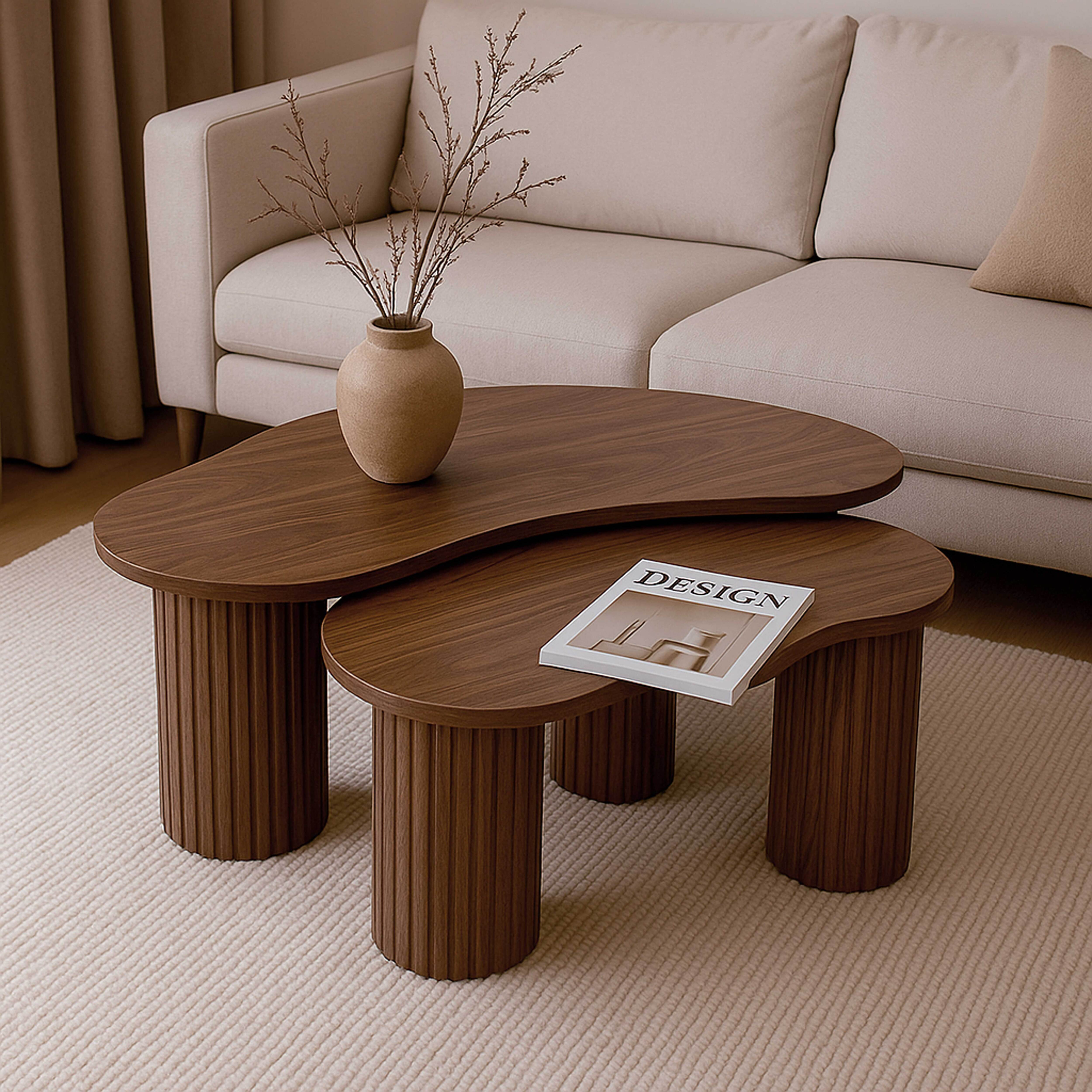 Ein Wohnzimmerszene zeigt einen Couchtisch mit einer Zeitschrift, einem Sofa, einer Vase mit Zweigen auf einem beigen Teppich.