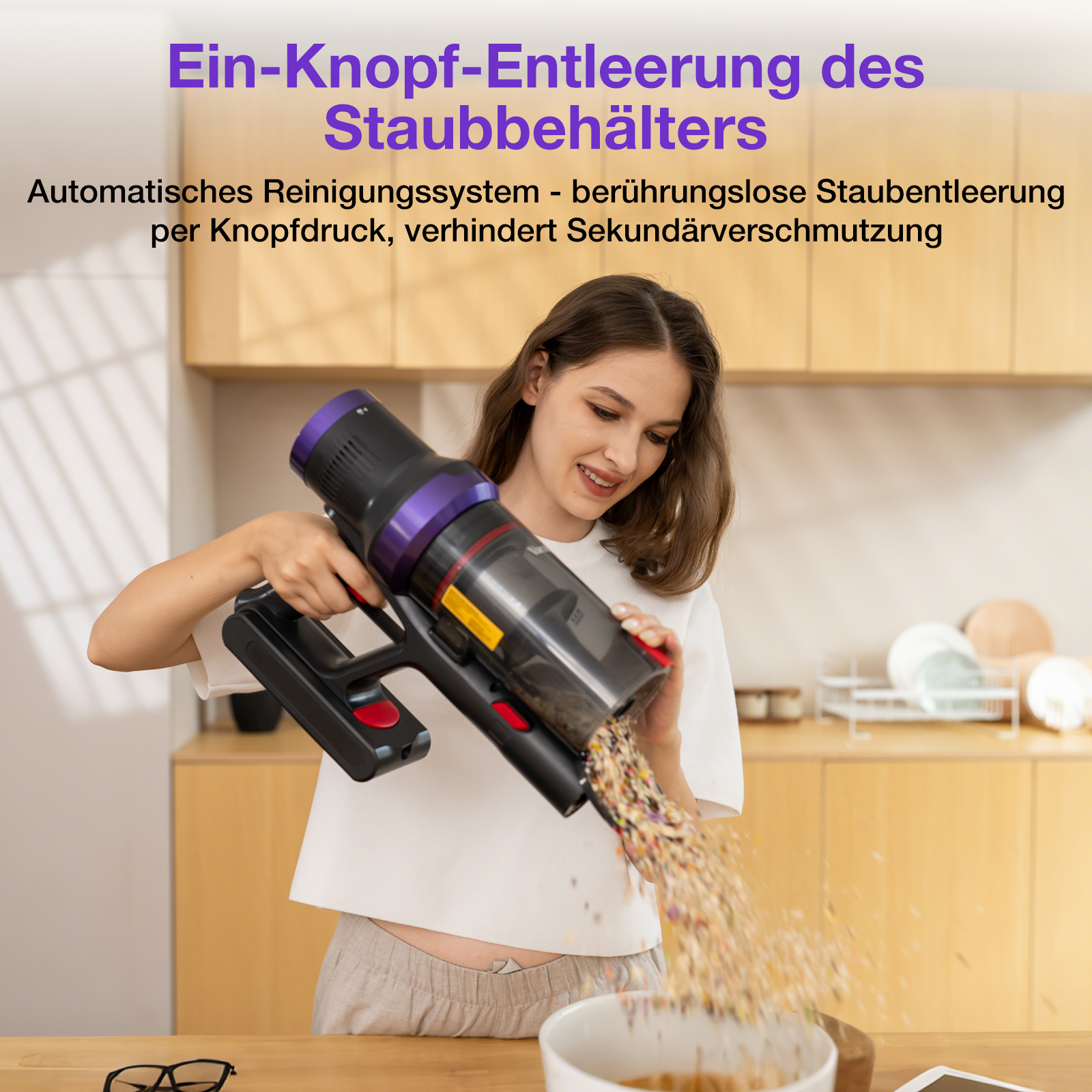 Eine Frau entleert einen Staubsauger in eine Schüssel. Der Staubsauger ist schwarz und lila. Küche im Hintergrund.