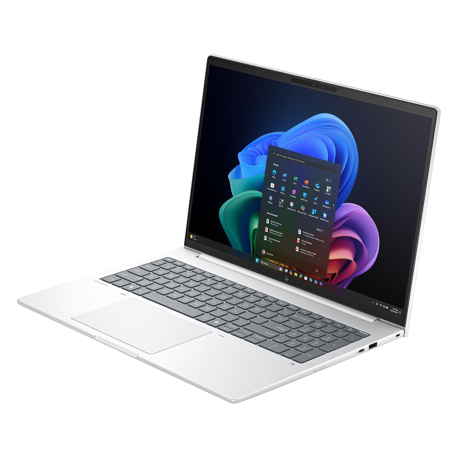 Un laptop argentato è aperto, mostra il menu Start di Windows. La tastiera è visibile e lo schermo mostra icone di app.