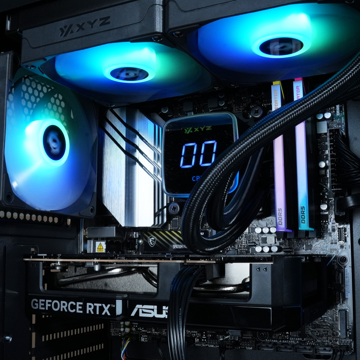 Dentro de una caja de computadora, una tarjeta gráfica, un enfriador de CPU con ventiladores LED, memorias RAM y una pantalla digital. Los componentes están iluminados en azul y verde.