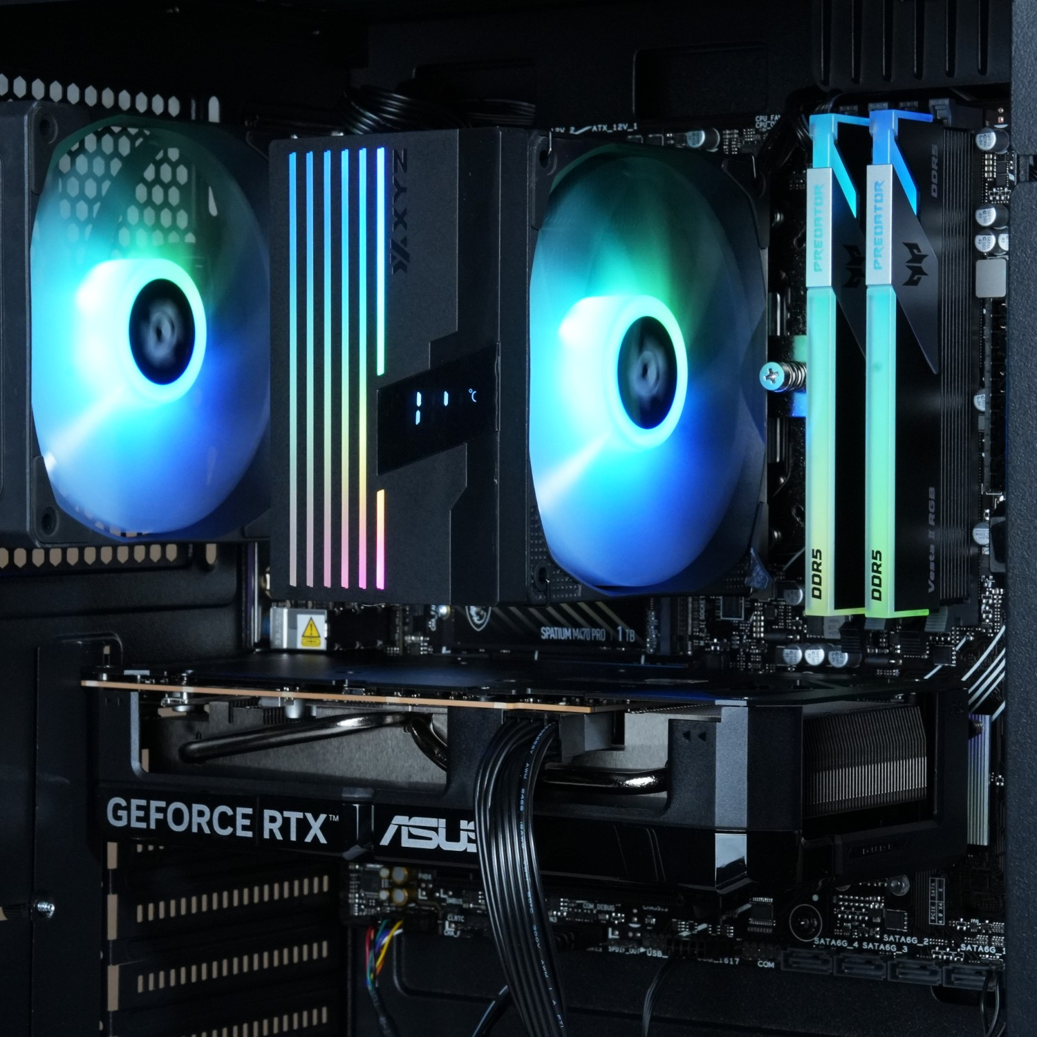 Dentro de una carcasa de ordenador, mostrando componentes como una GPU, un refrigerador de CPU, RAM y una placa base. Se ve iluminación RGB.