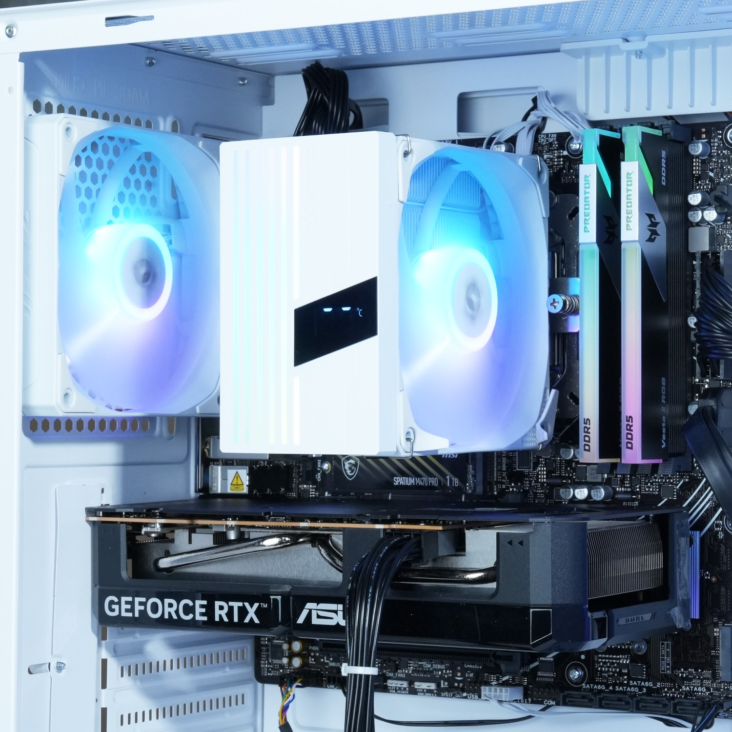 Dentro de una carcasa de computadora: un enfriador de CPU con ventiladores, RAM, una tarjeta gráfica GeForce RTX y una placa base.