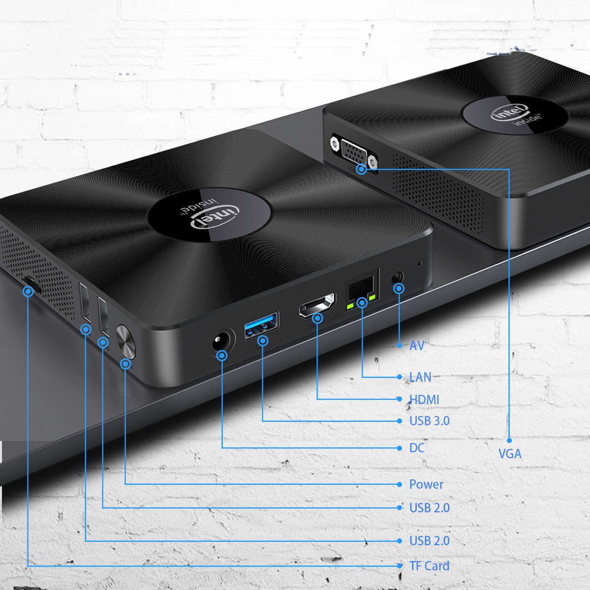 Dos mini PC negros en una estantería. Etiquetas indican puertos: USB, HDMI, LAN, alimentación y VGA. El logotipo de Intel visible.