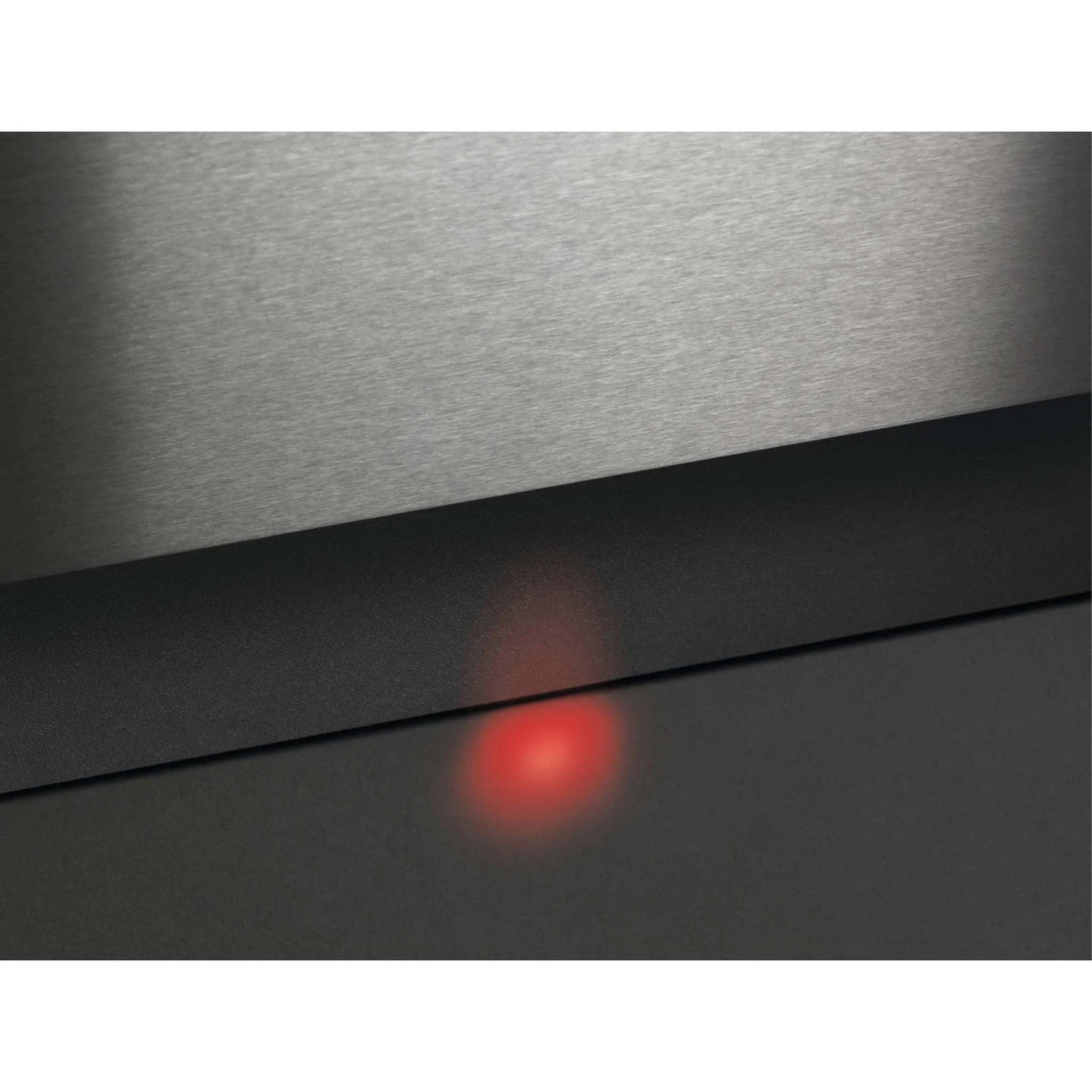 Zbliżenie metalowej powierzchni z ciemnym pasem i czerwonym podświetlonym okręgiem.