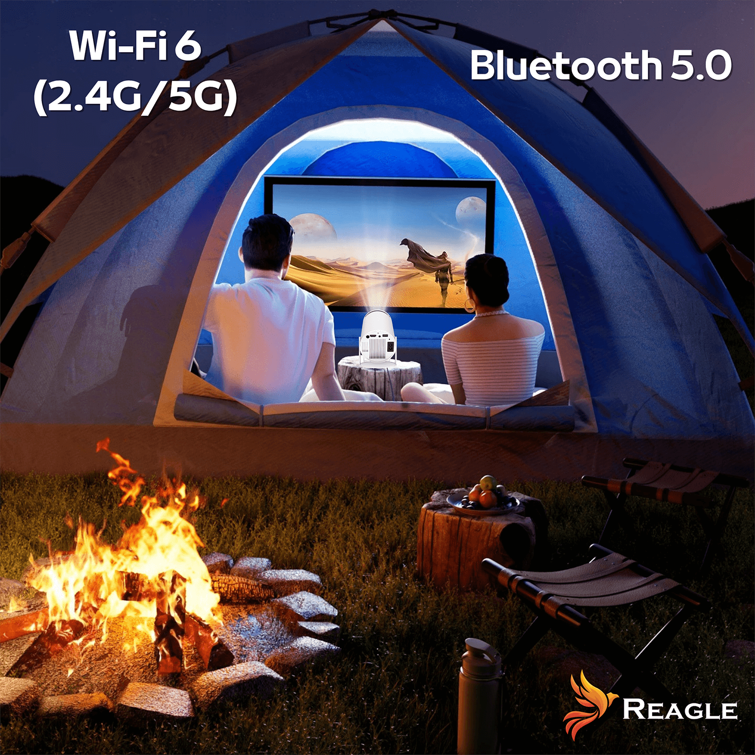 Dwie osoby w namiocie oglądają ekran. Ognisko z przodu. Owoce na pniu. Widoczne symbole Bluetooth i Wi-Fi.