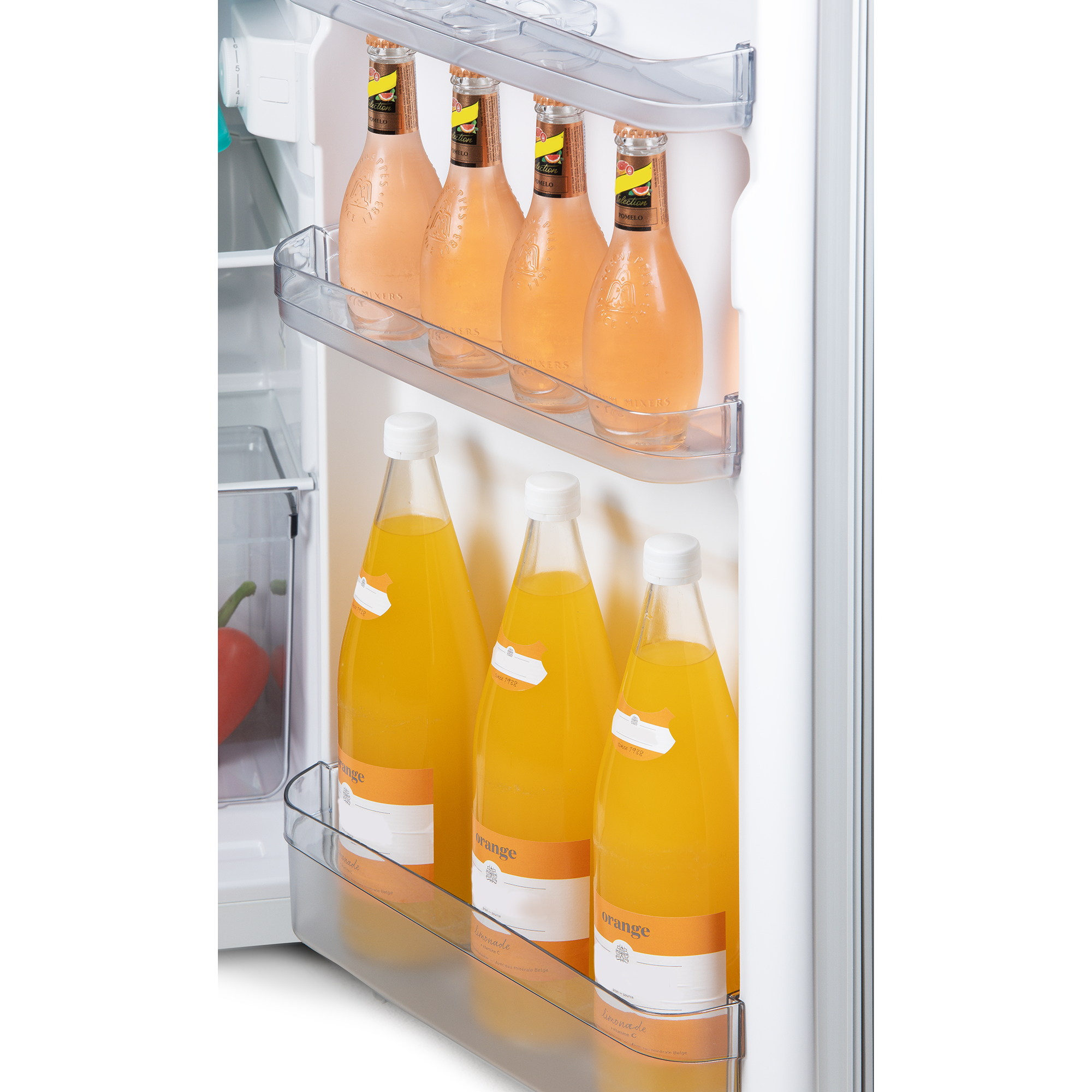 À l'intérieur d'un réfrigérateur, des bouteilles de jus rose et de jus d'orange sont affichées sur des étagères. La porte est blanche.