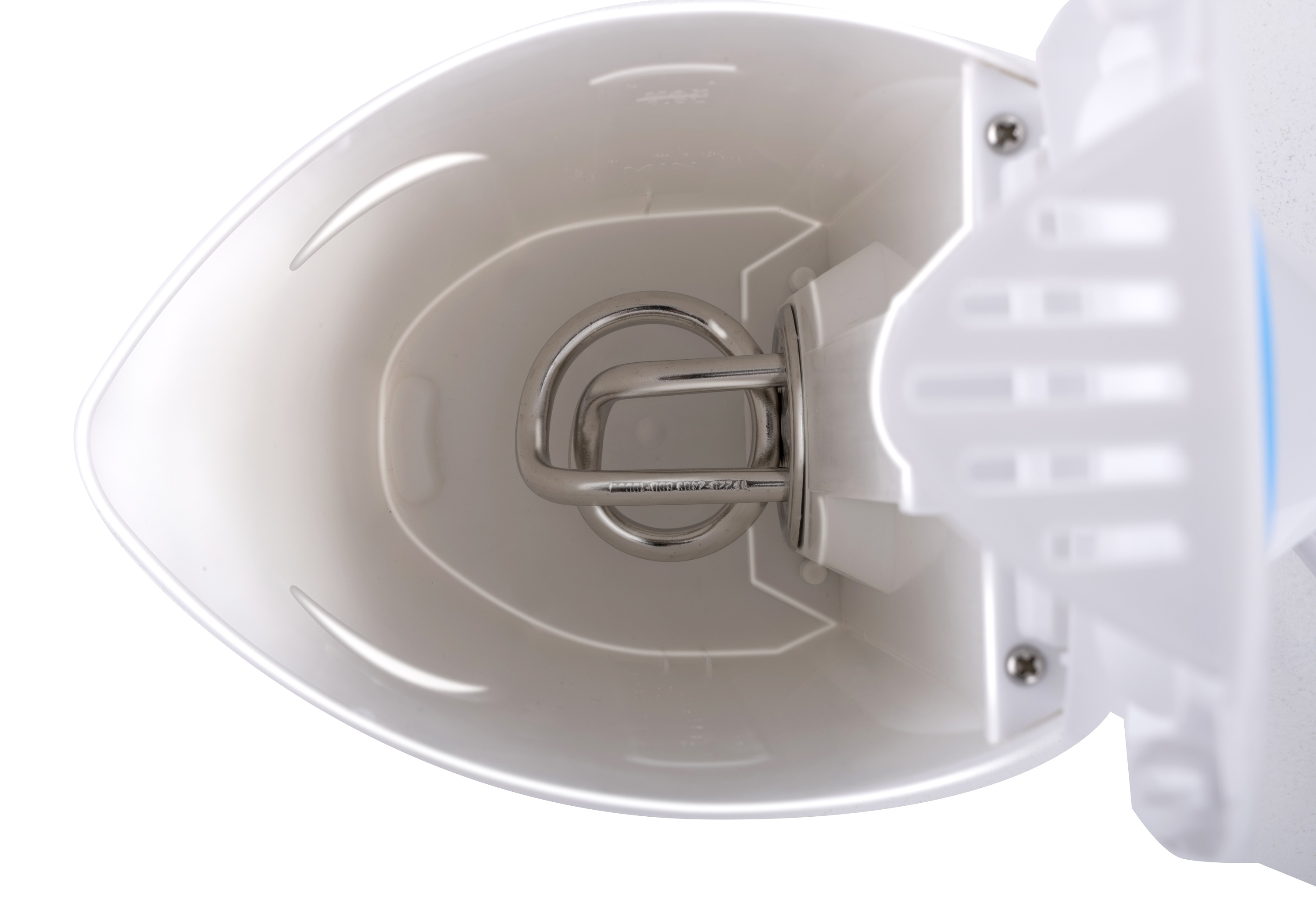 Primo piano dell'interno di un bollitore elettrico bianco. All'interno c'è un elemento riscaldante a spirale.