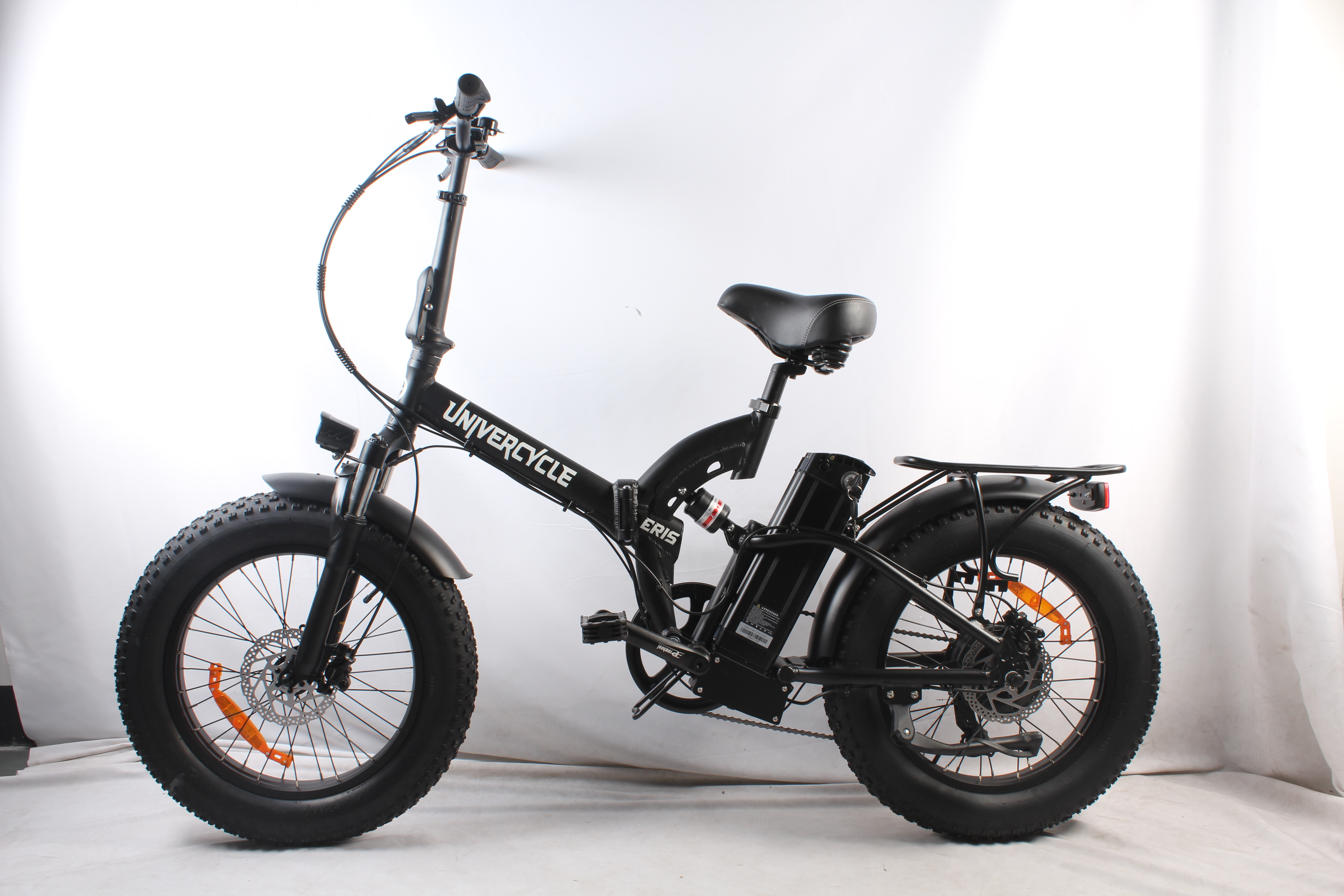 Bicicletta elettrica nera su sfondo bianco. Pneumatici spessi, batteria e nome 'UNIVERCYCLE'.