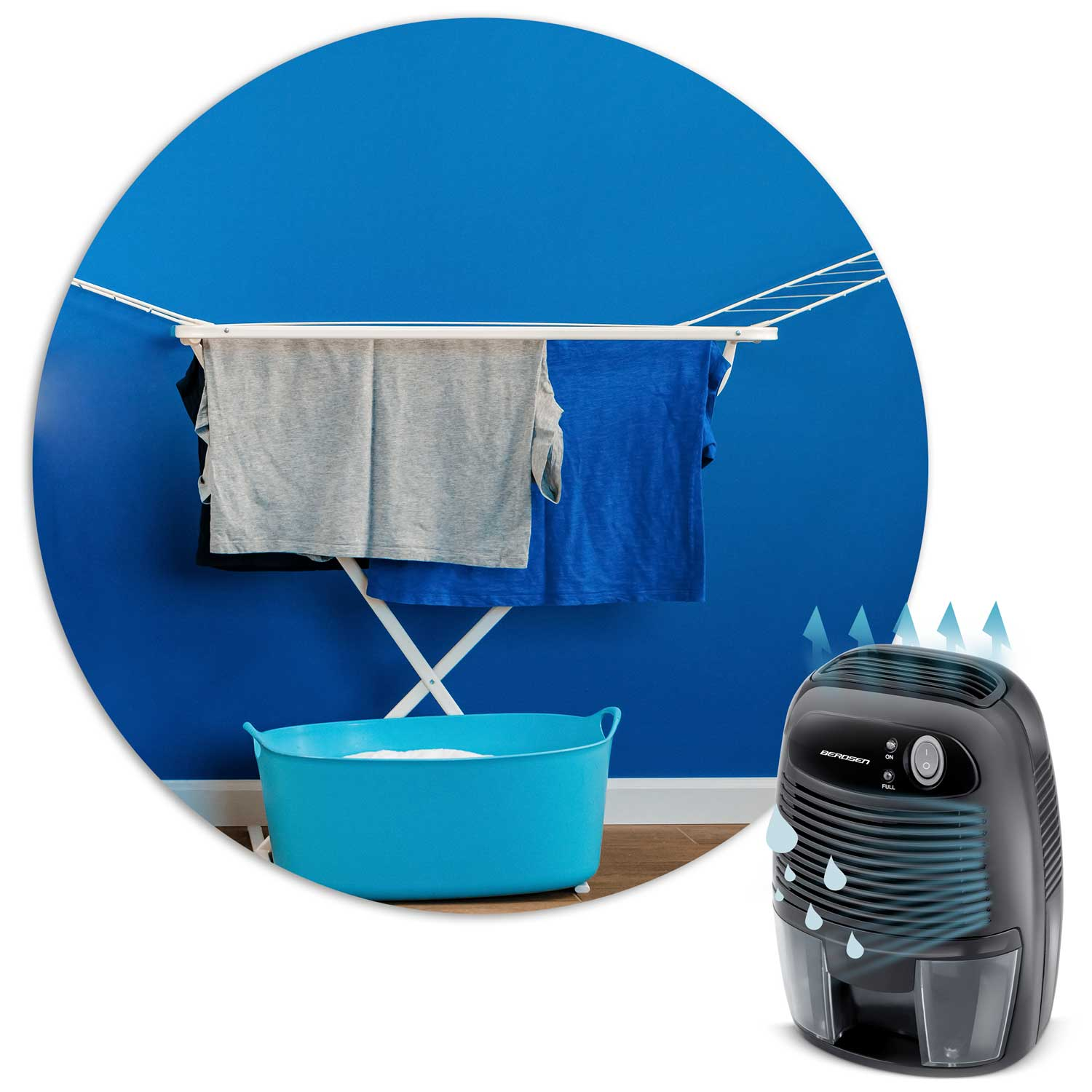 Ubrania schną na suszarce w pomieszczeniu. Po prawej stronie osuszacz powietrza, krople wody i strzałki wskazują jego funkcję. Niebieska ściana i wanna.