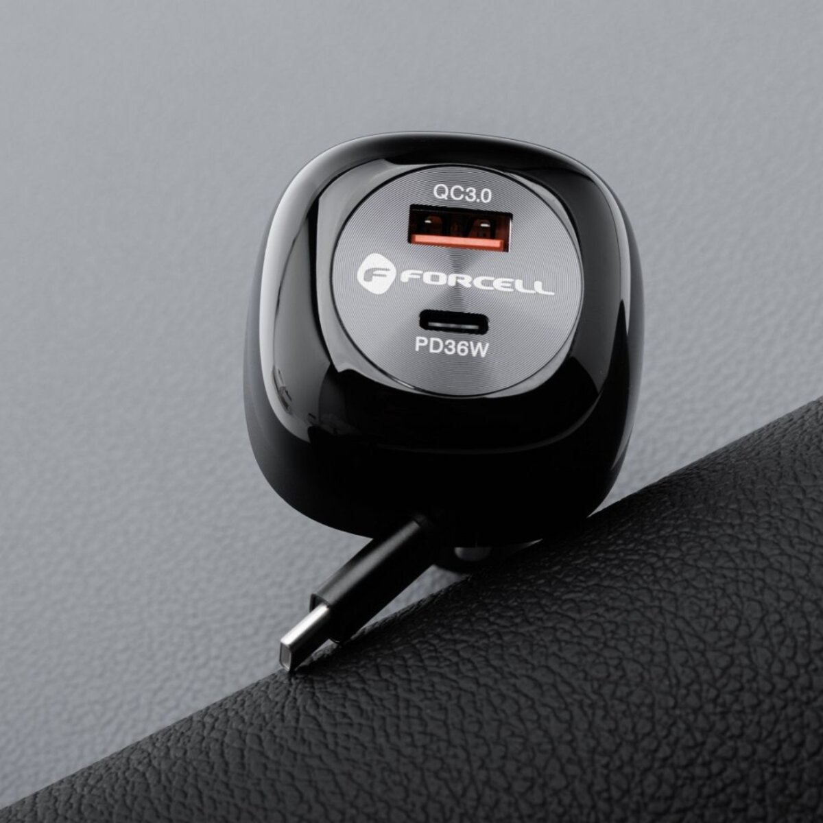 Chargeur de voiture noir avec port USB, marque 'FORCELL' visible. Posé sur surface noire texturée.