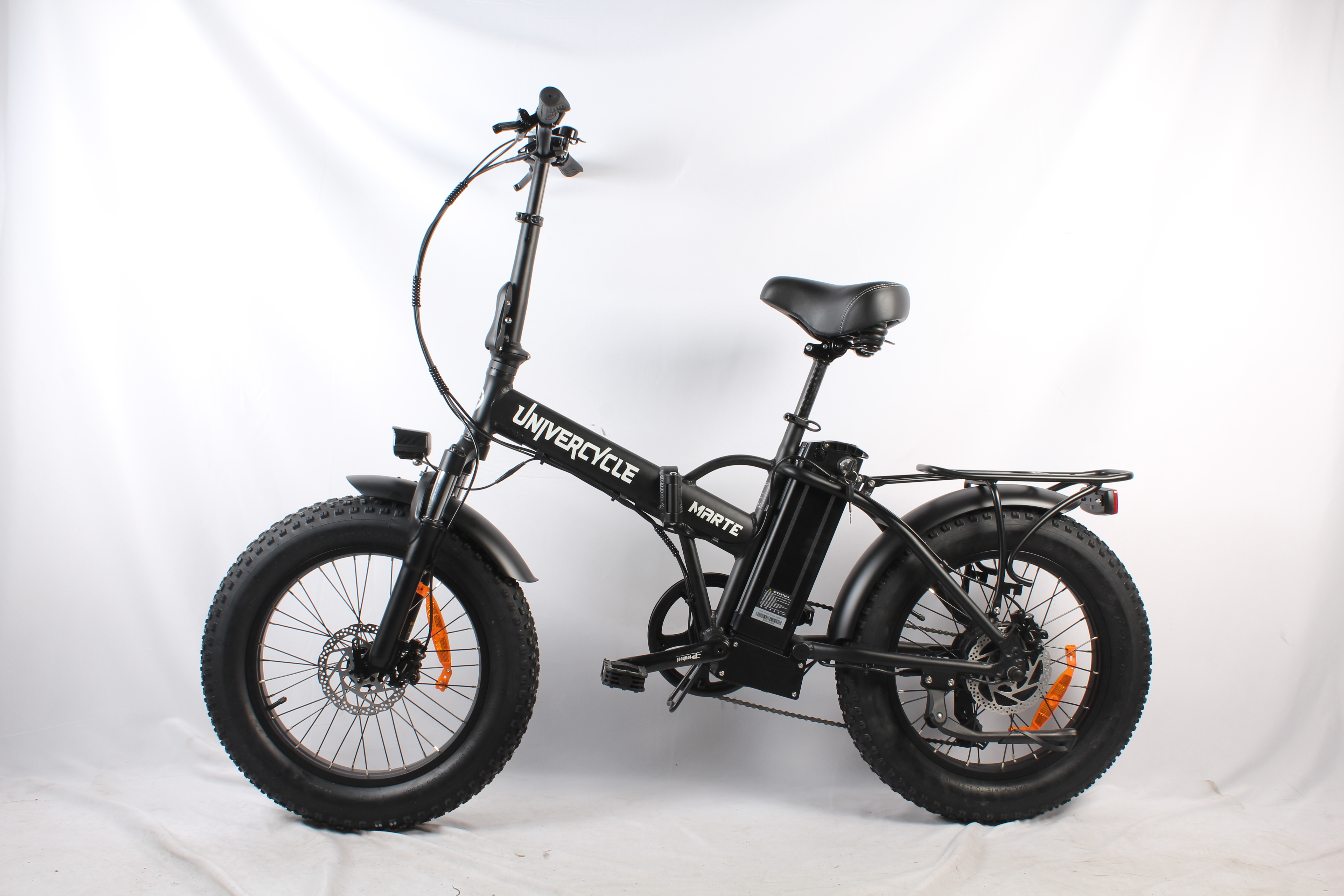 Una bici elettrica nera Unicycle Marte con pneumatici spessi su sfondo bianco. La bici è piegata.