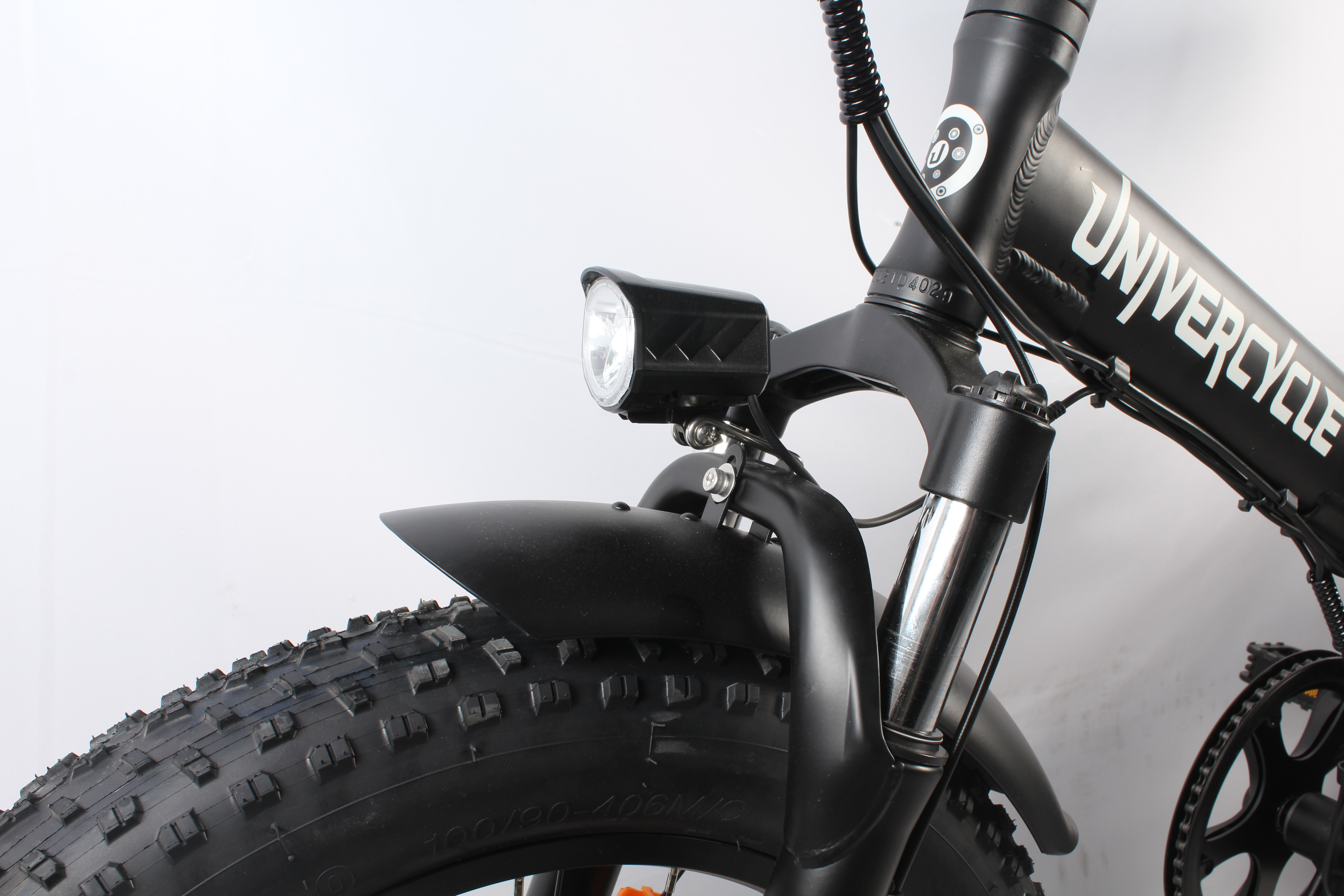 Primo piano della parte anteriore di una bicicletta elettrica nera. Include luce, pneumatico, parafango e marchio UNIVERCYCLE.