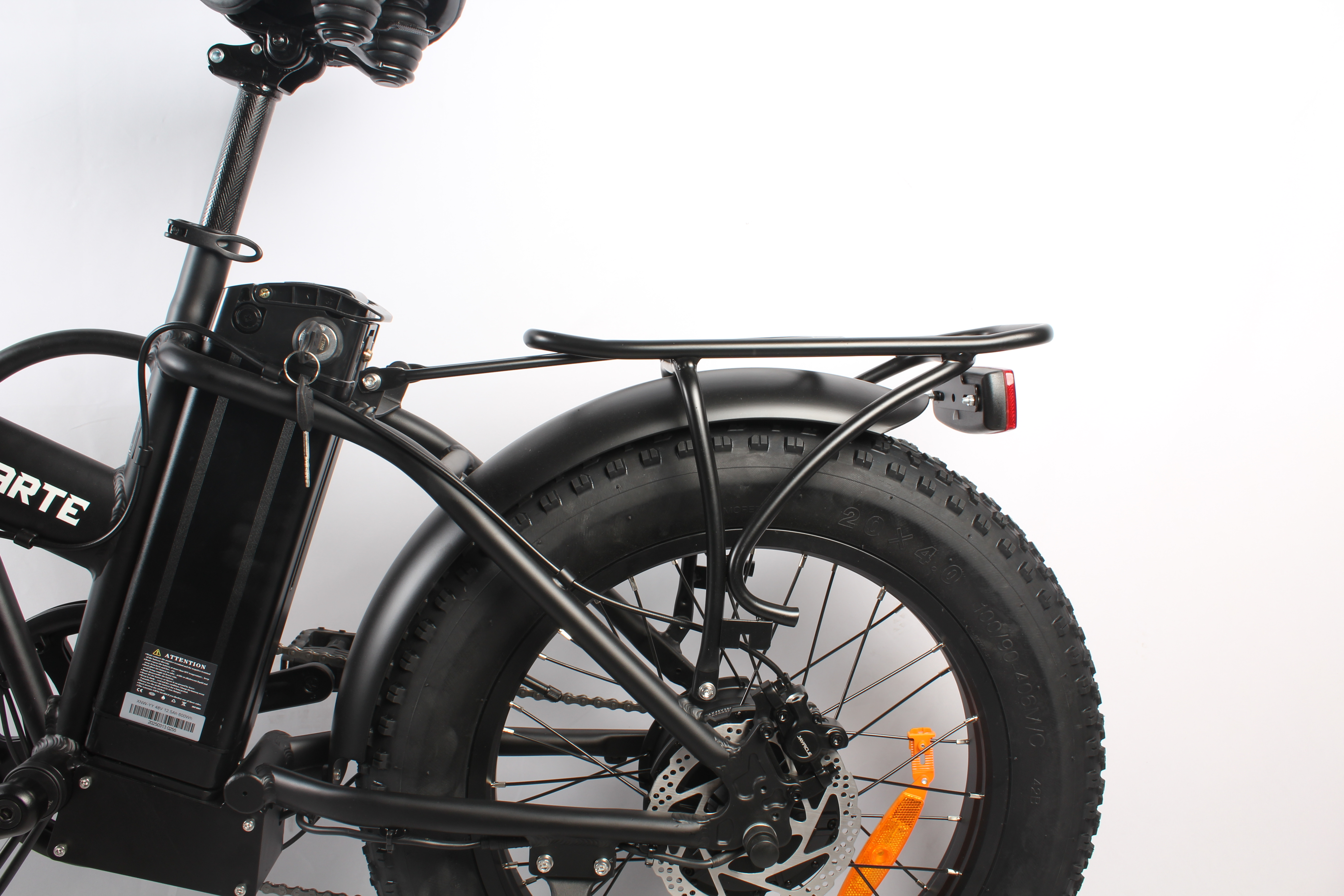 Parte posteriore di bici elettrica nera. Pneumatico, parafango, portapacchi e freno a disco visibili. Catarifrangente arancione.