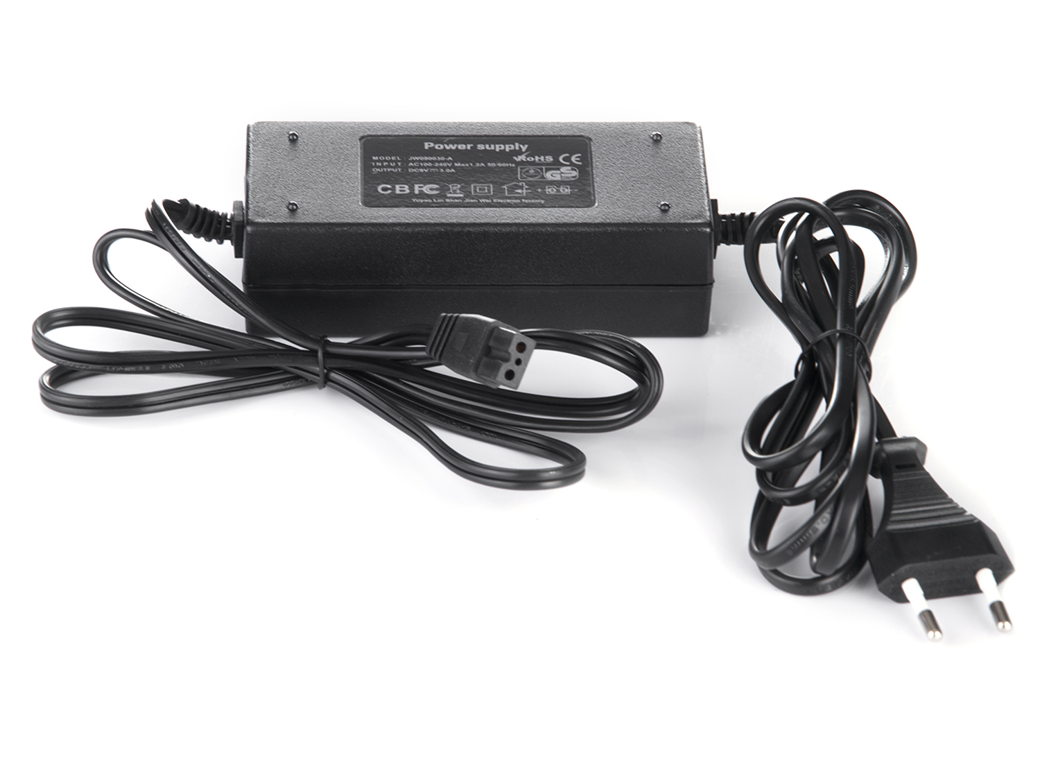 Czarny zasilacz z podłączonymi kablami i wtyczką na białym tle. Zasilacz ma tekst na swojej powierzchni.