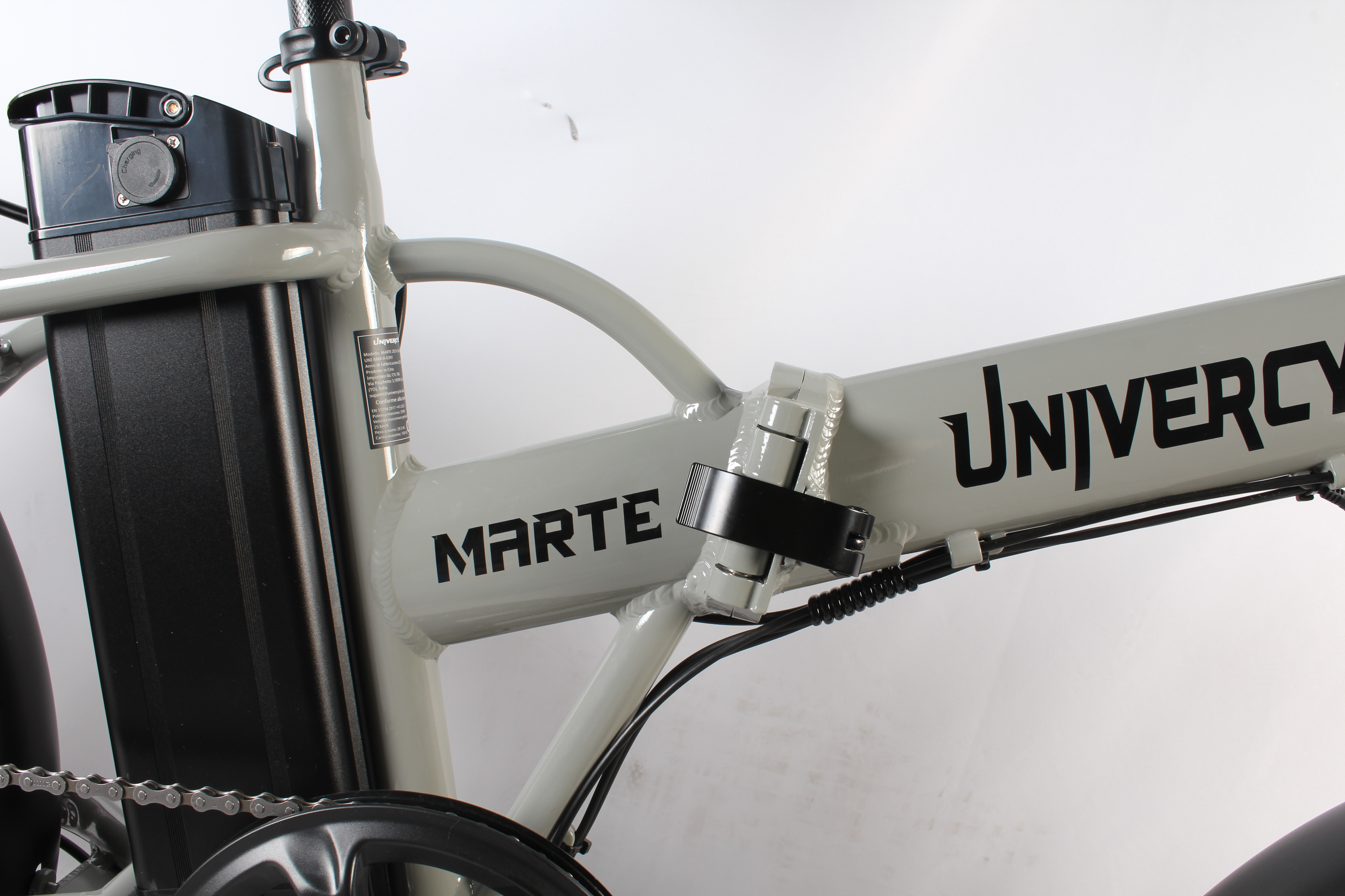 Vista parziale di una bicicletta elettrica grigio chiaro con componenti e marchio neri. Lo sfondo è bianco.