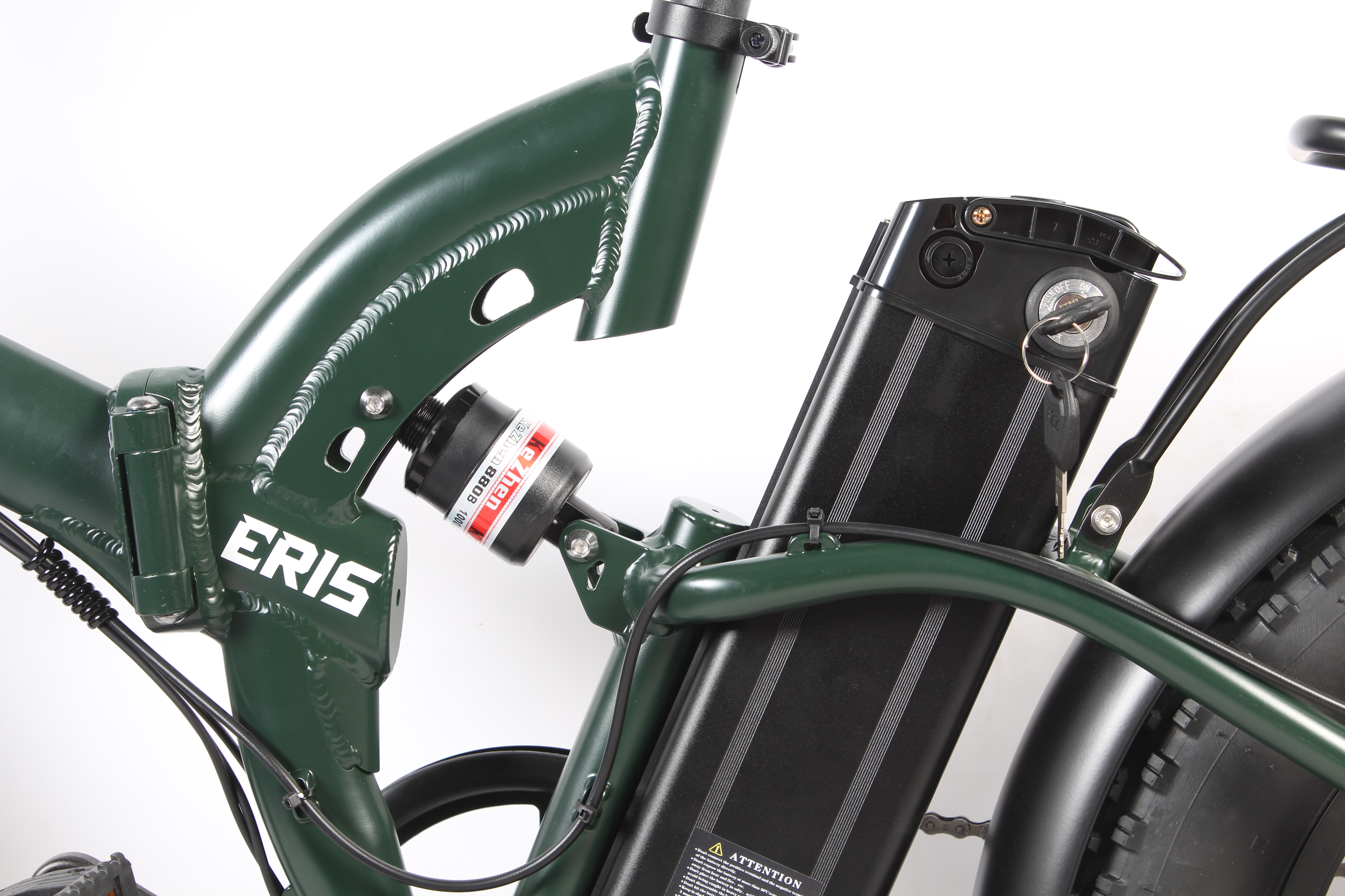 Primo piano di un telaio di e-bike verde, batteria nera e sospensioni. Il marchio 'ERIS' è visibile.