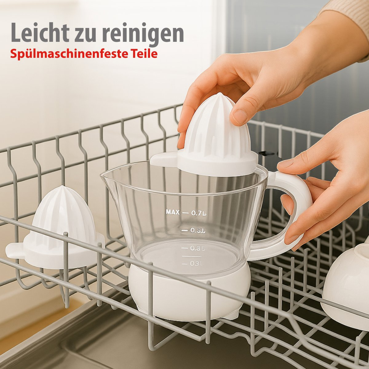 Ein weißer Zitruspresse wird in eine Spülmaschine gestellt. Eine Hand hält die Oberseite der Presse. Die Presse steht auf einem Messbecher.