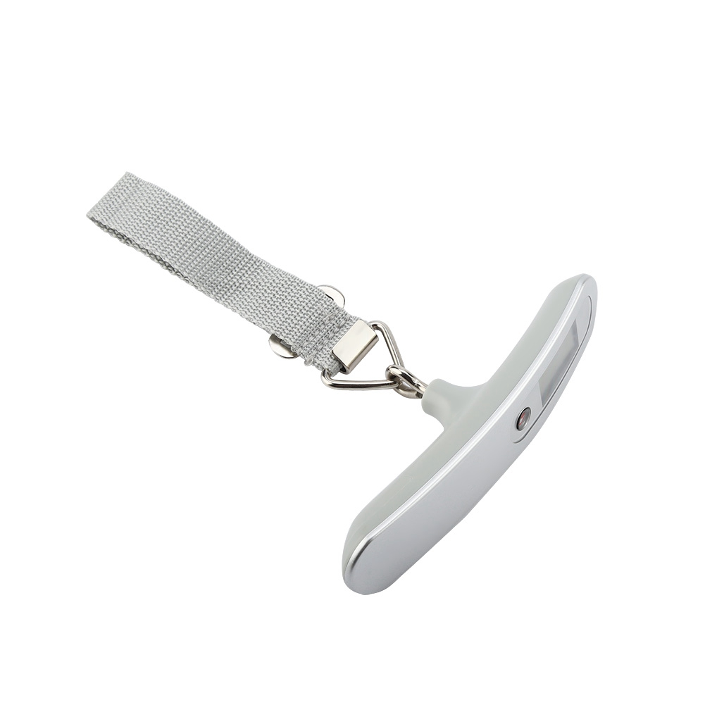Eine graue Gepäckwaage mit einem Gurt. Die Waage ist T-förmig mit Digitalanzeige. Der Gurt ist mit einem Metallverschluss befestigt.
