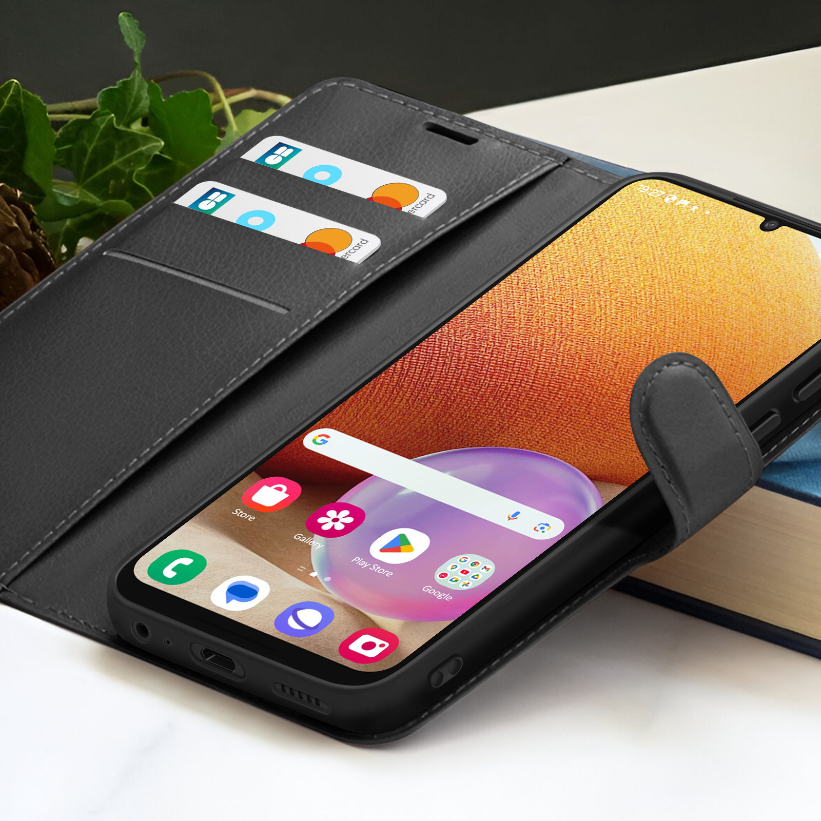 Un smartphone dans un étui noir avec des cartes à l'intérieur. Le téléphone affiche des icônes d'applications. L'étui est sur une surface.